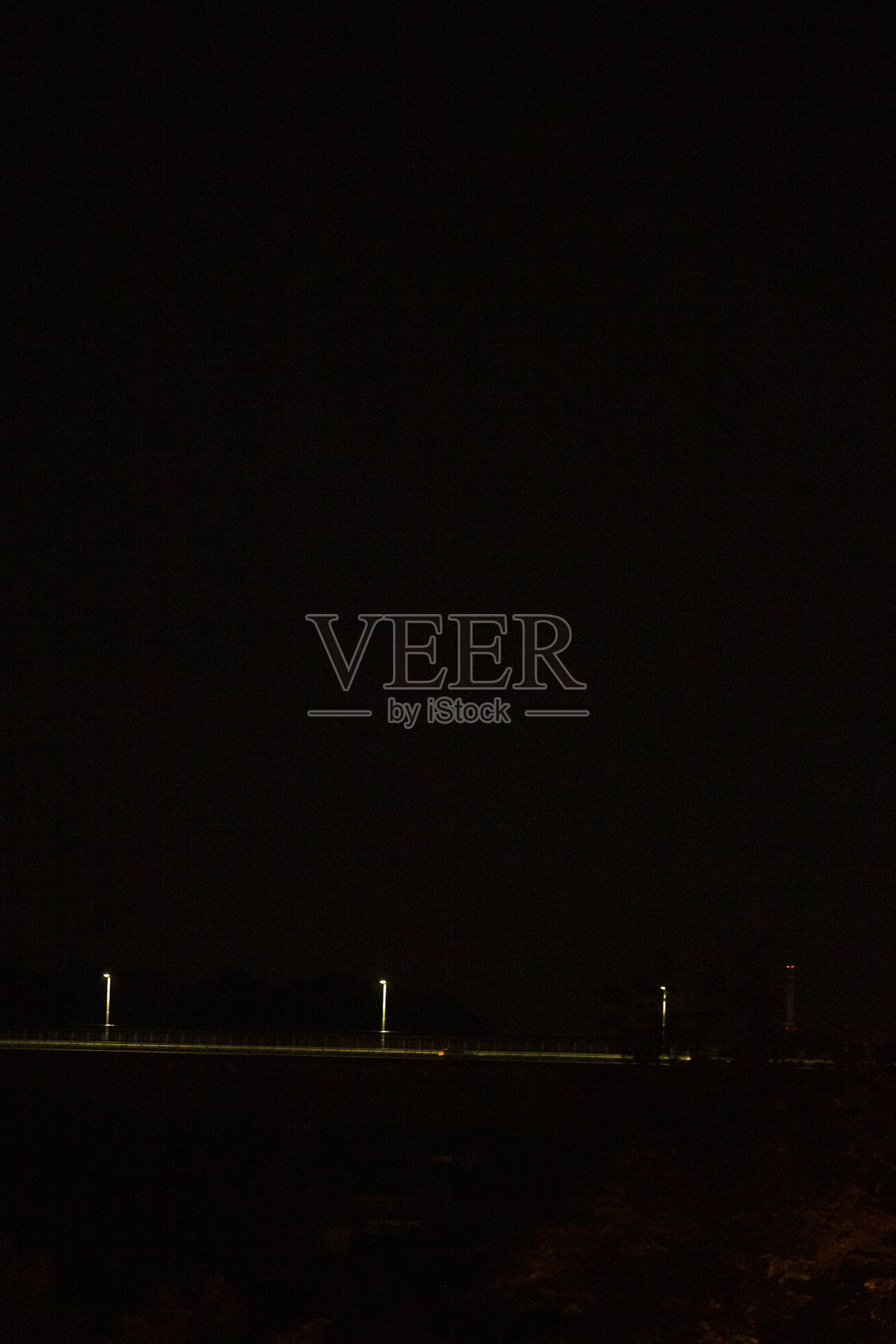 黑暗的城市景观，孤零零的路灯照亮了废弃的高速公路照片摄影图片