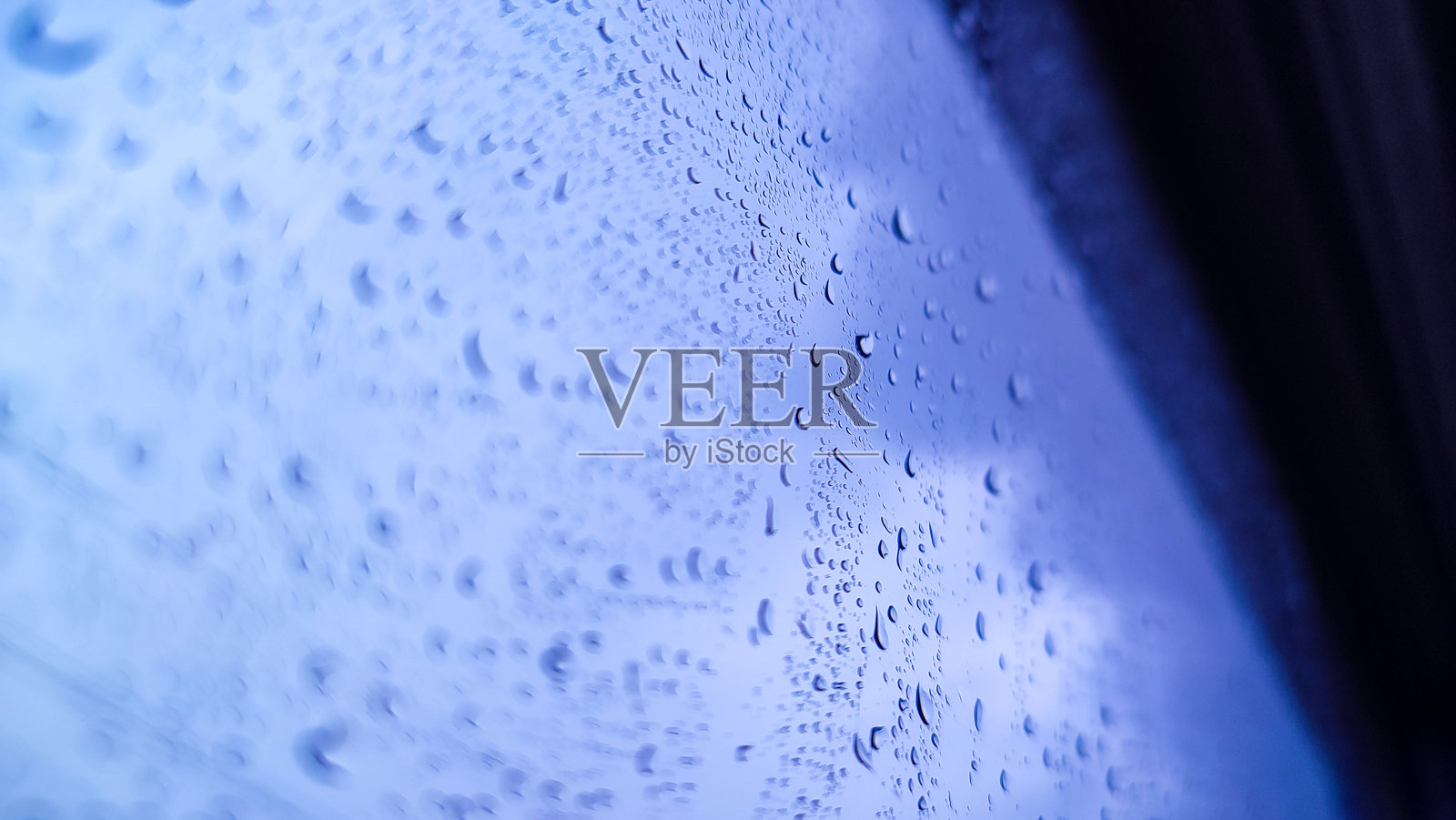雨滴落在模糊的公路背景的玻璃窗上照片摄影图片