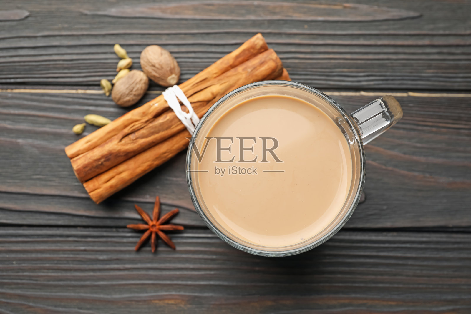 玻璃杯中的香料茶和木桌上的香料，俯视角度照片摄影图片