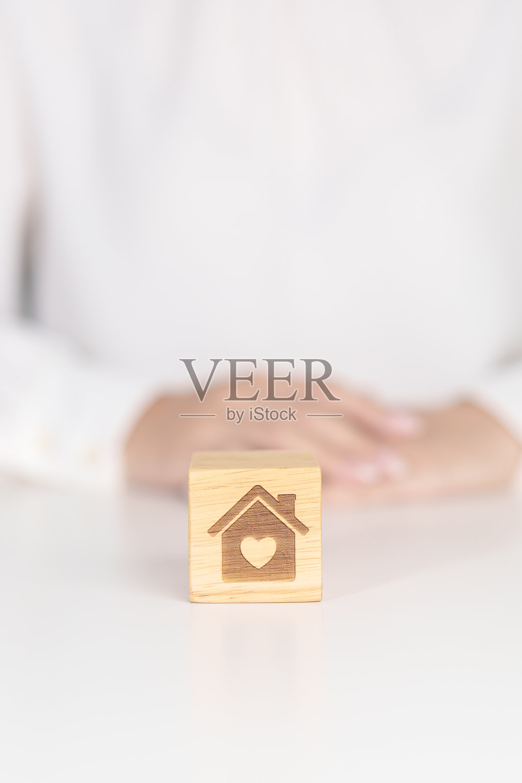 手持带心形方块的房子。投资房产、房屋抵押、房产税、无家可归、捐赠、财务和幸福家庭概念照片摄影图片