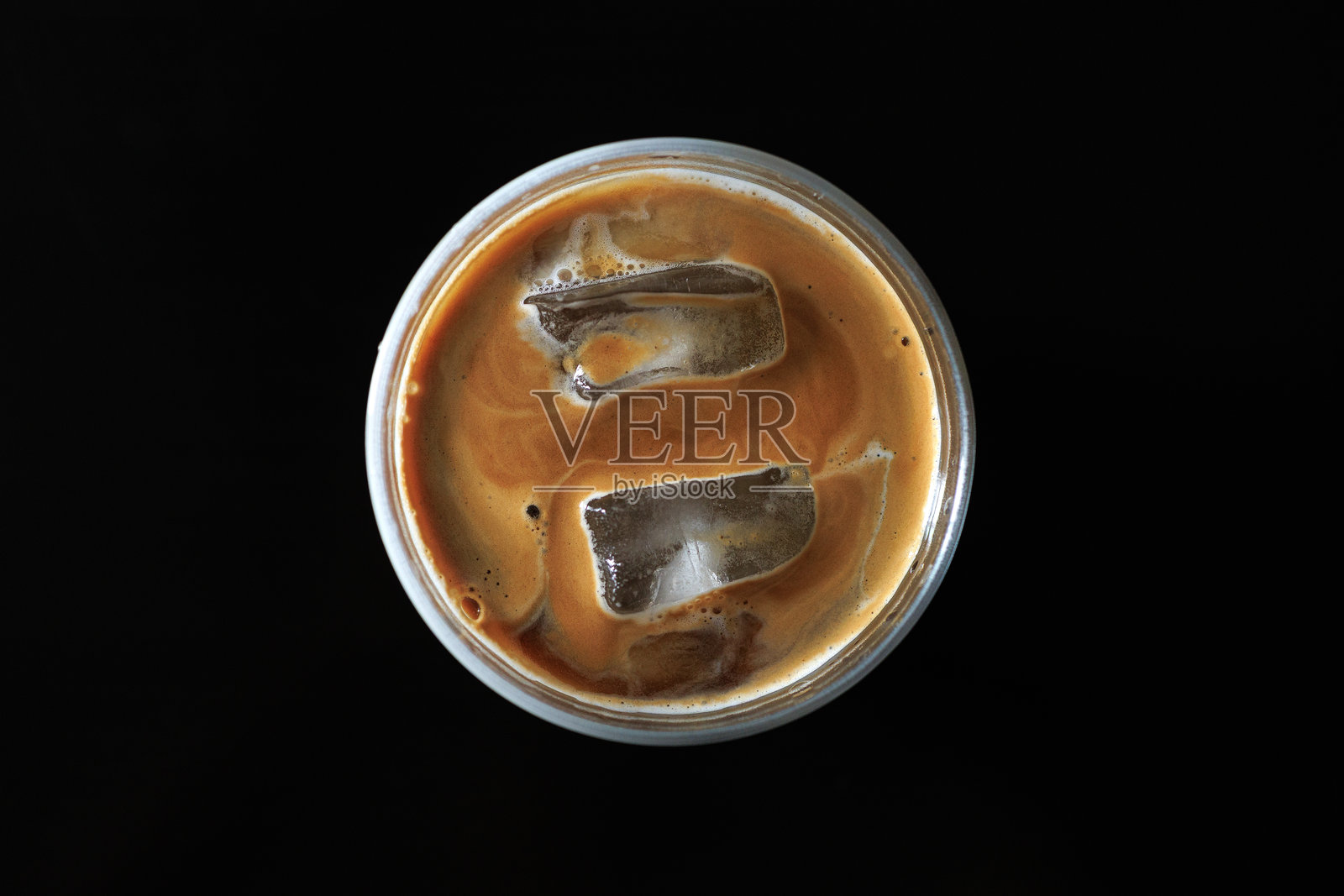 黑色背景下，一杯冰块满满的冰咖啡俯视角度照片摄影图片