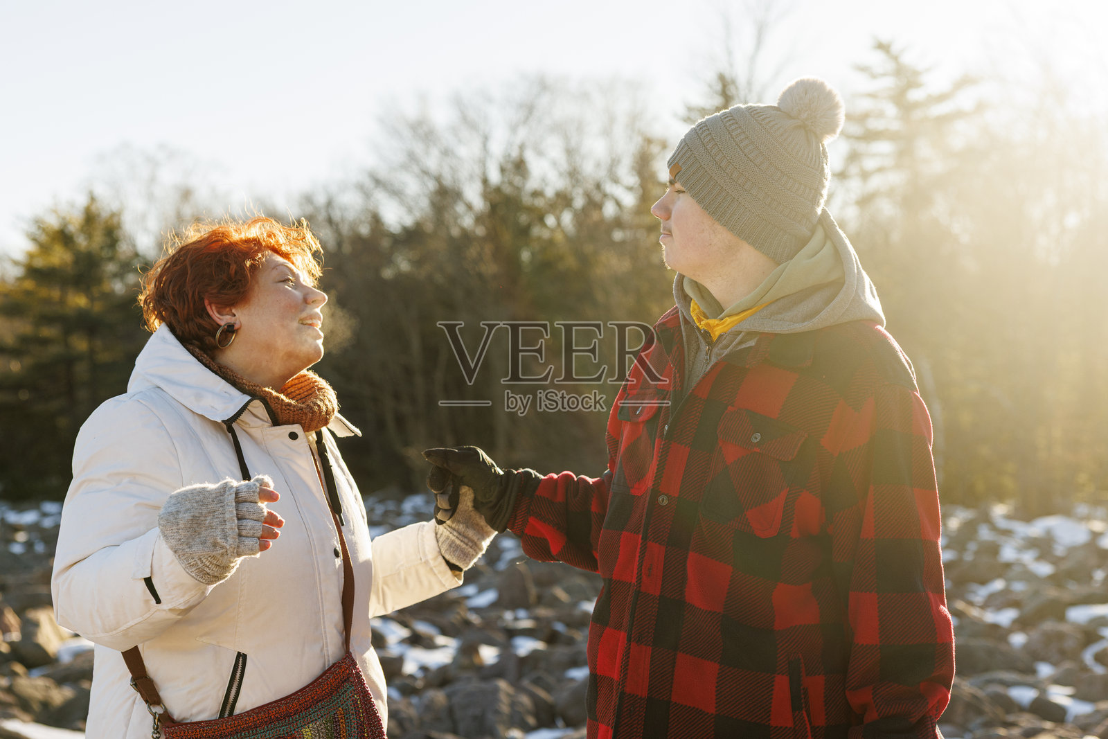 红发母亲与她19岁的自闭症儿子牵手，母子情深。一家人在宾夕法尼亚州希科里跑州立公园享受阳光明媚的冬日午后。照片摄影图片