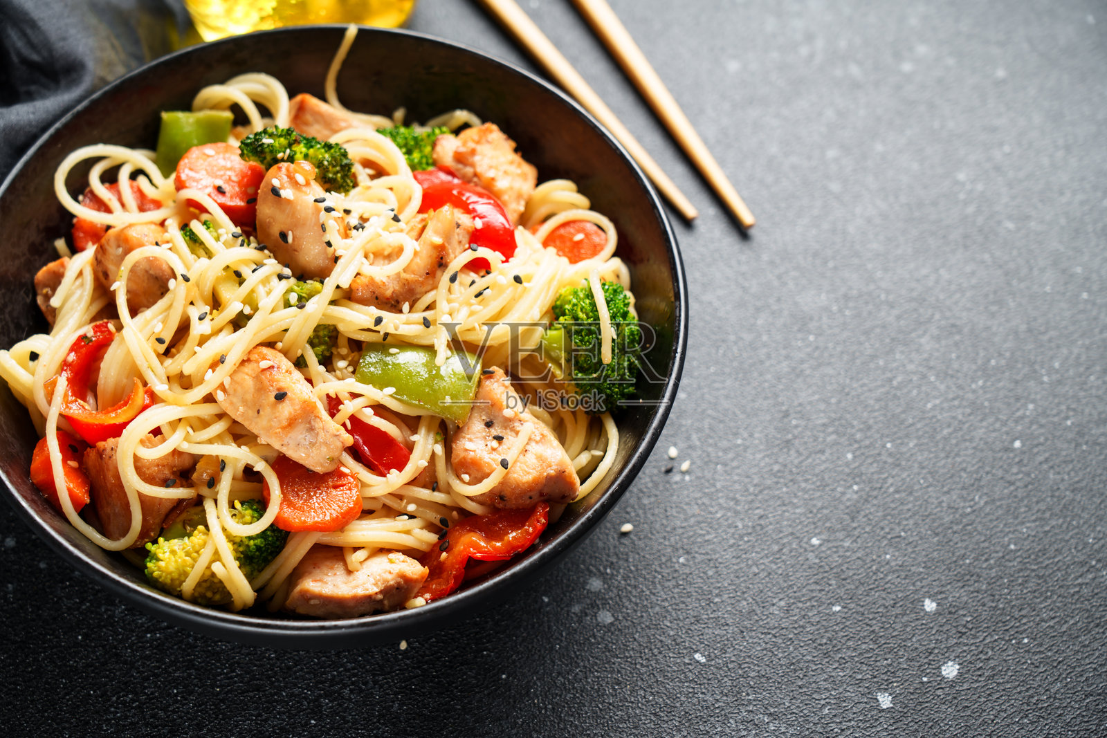 黑色背景上的亚洲鸡肉蔬菜面条。特写。照片摄影图片