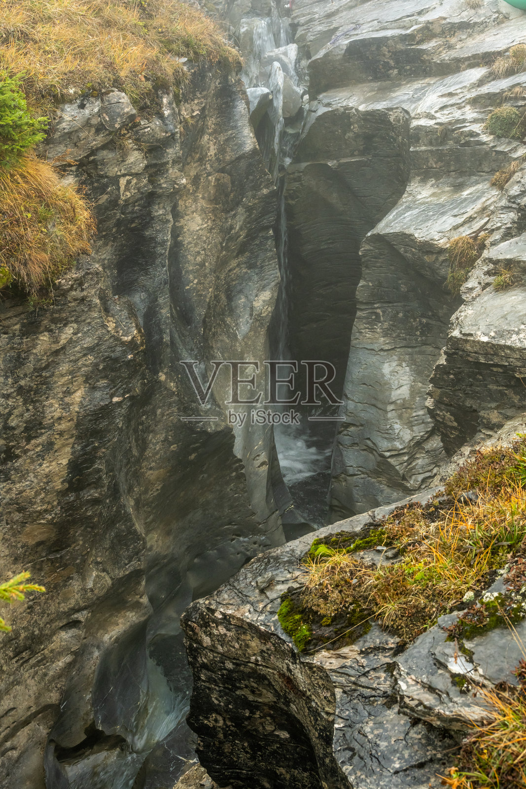 艾格峰下，桑德巴赫峡谷狭窄的岩壁间的小瀑布照片摄影图片