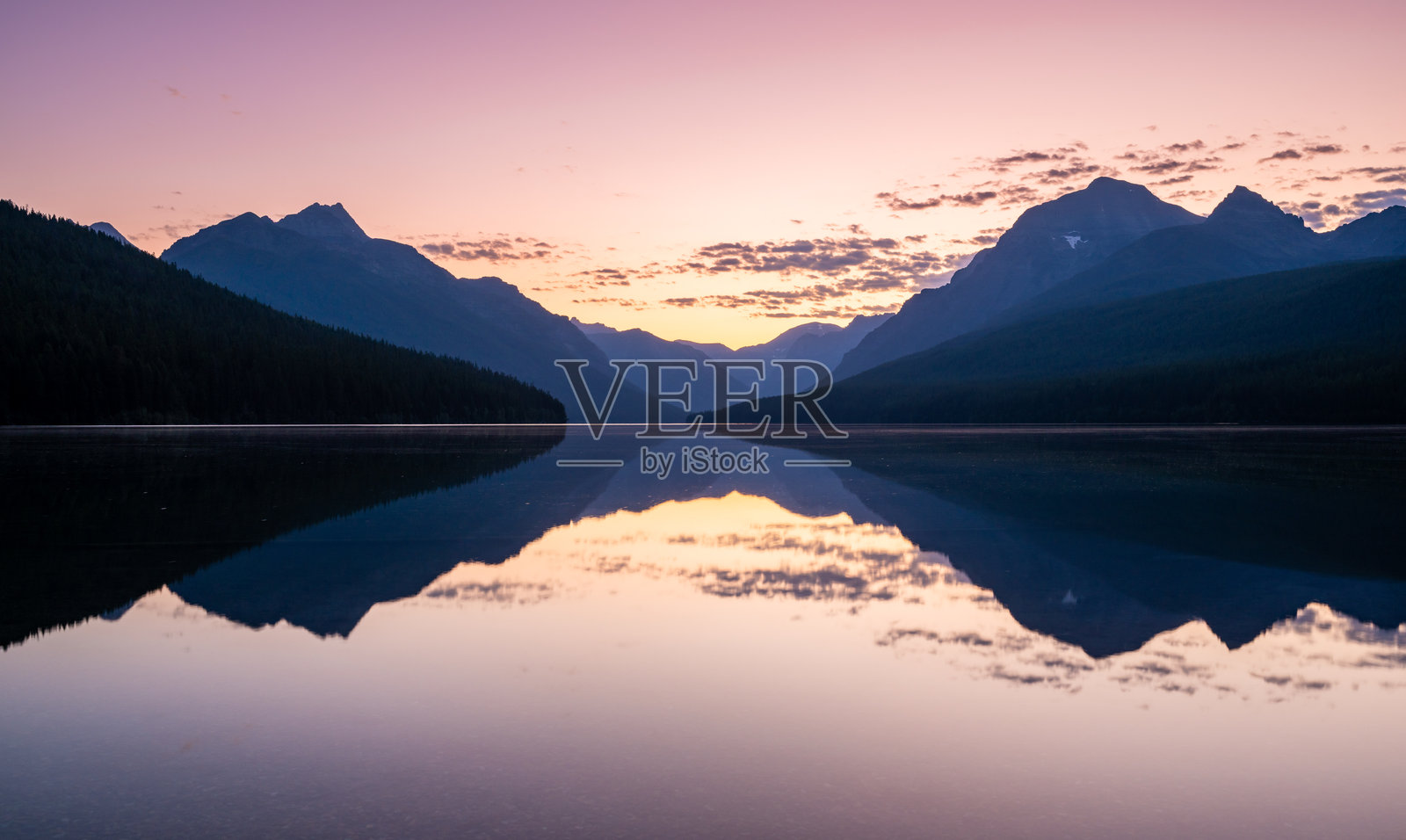 粉色的光芒映照在鲍曼湖平静的水面上照片摄影图片