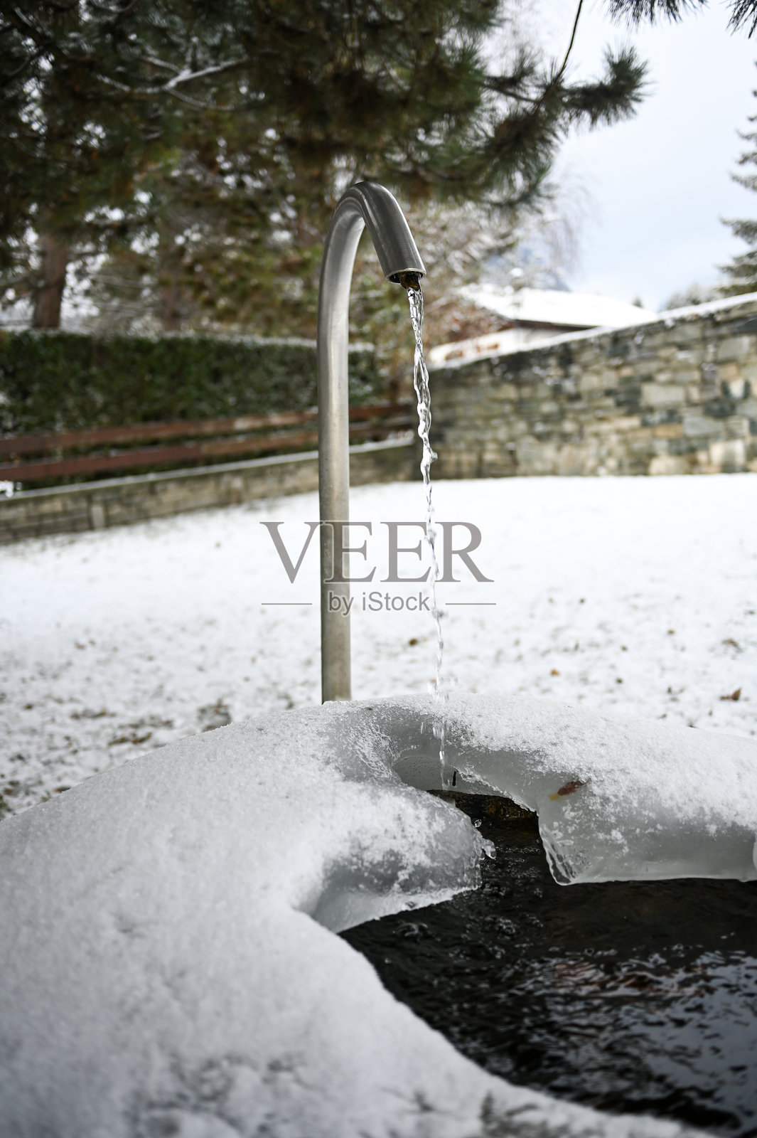 雪景冬季，金属喷泉涌出泉水照片摄影图片