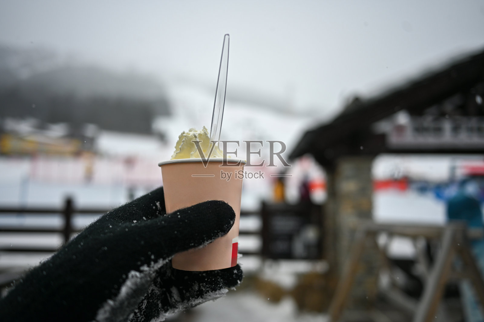 在雪景滑雪胜地手持加奶油的暖咖啡照片摄影图片