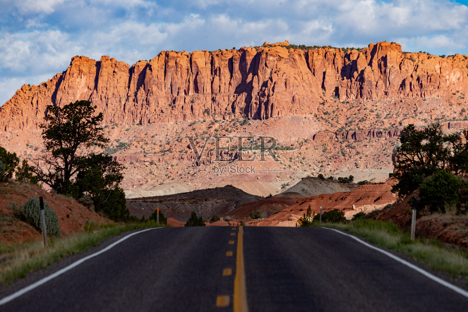 通往国会礁国家公园红色岩石悬崖的空旷道路照片摄影图片