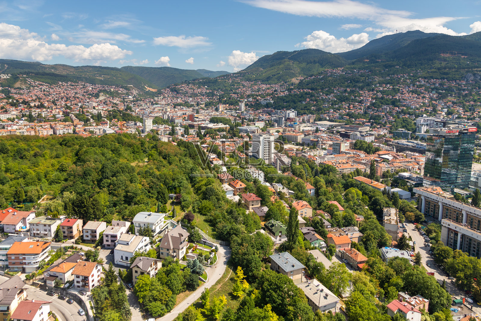 波斯尼亚和黑塞哥维那萨拉热窝城市天际线，包括现代办公楼和周边山脉。照片摄影图片