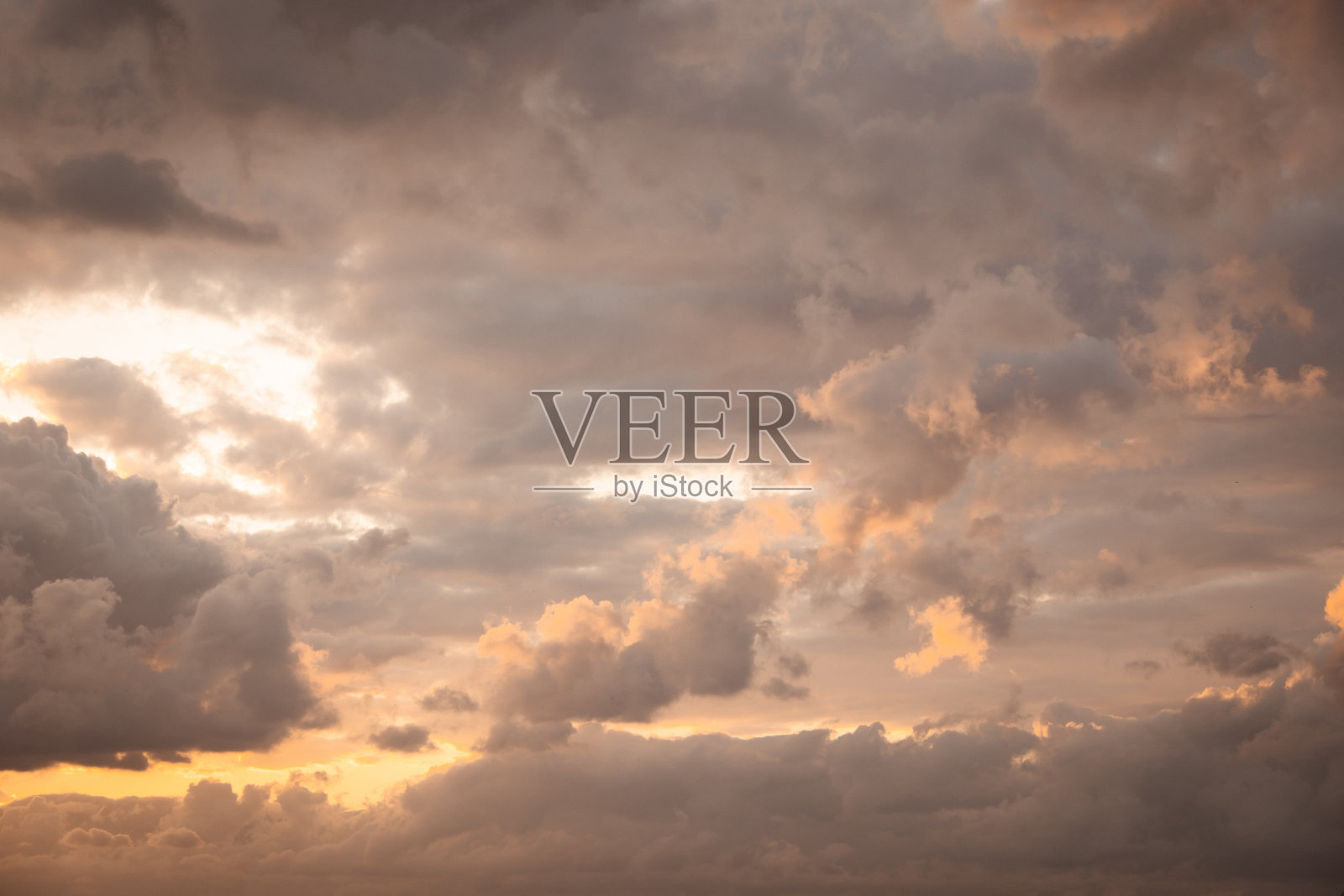 日出或日落时移动的暴风云渲染出戏剧性的天空，营造出具有温暖橙色和灰色调的动态自然背景照片摄影图片