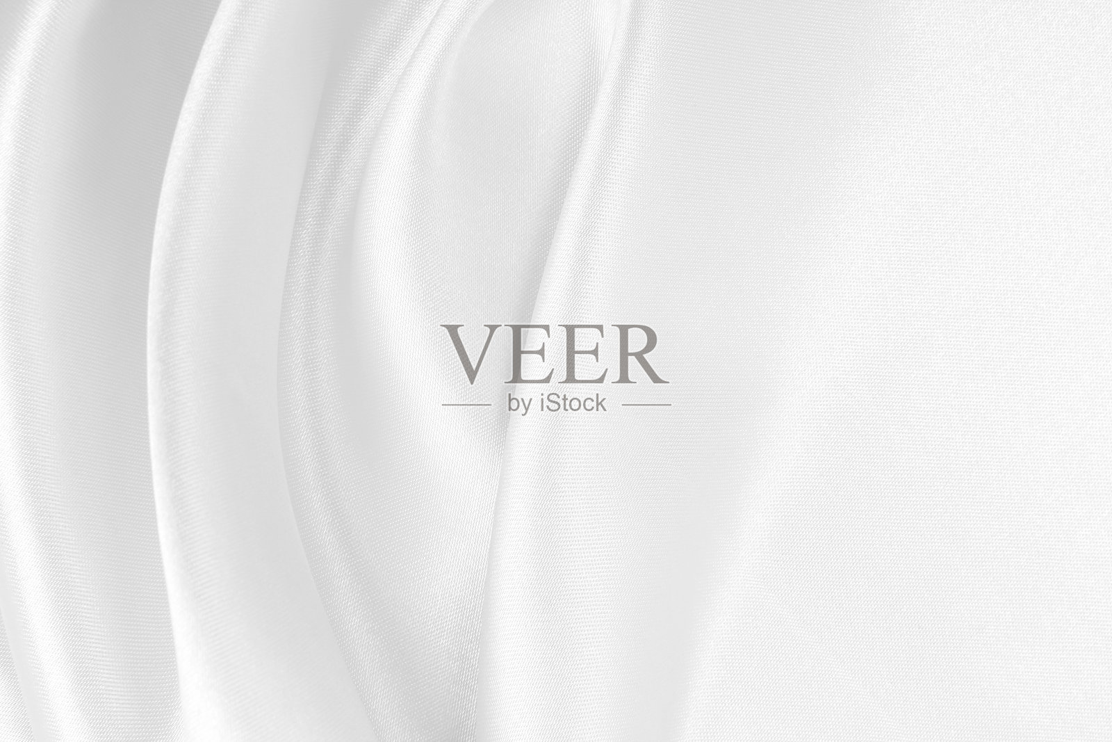 光滑优雅的白色丝绸或缎面奢华布料纹理，用作婚礼背景。奢华背景设计。照片摄影图片