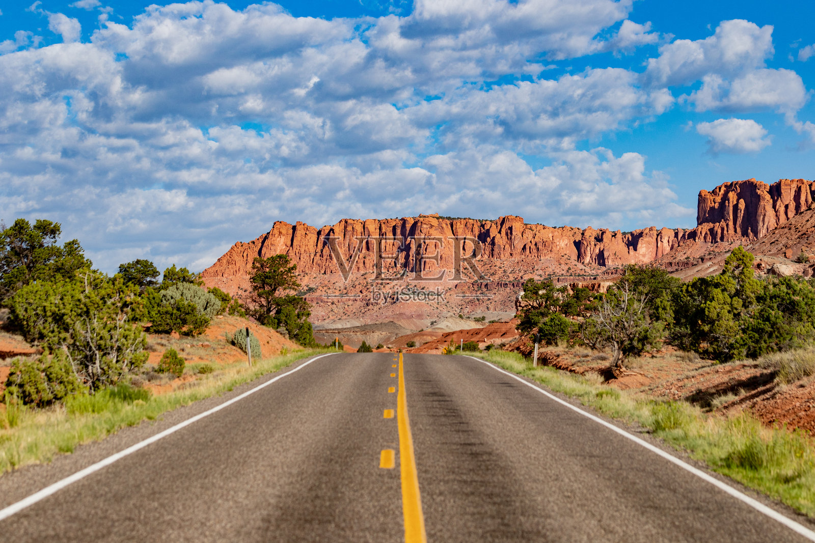 通往国会礁国家公园红色岩石悬崖的空旷道路照片摄影图片