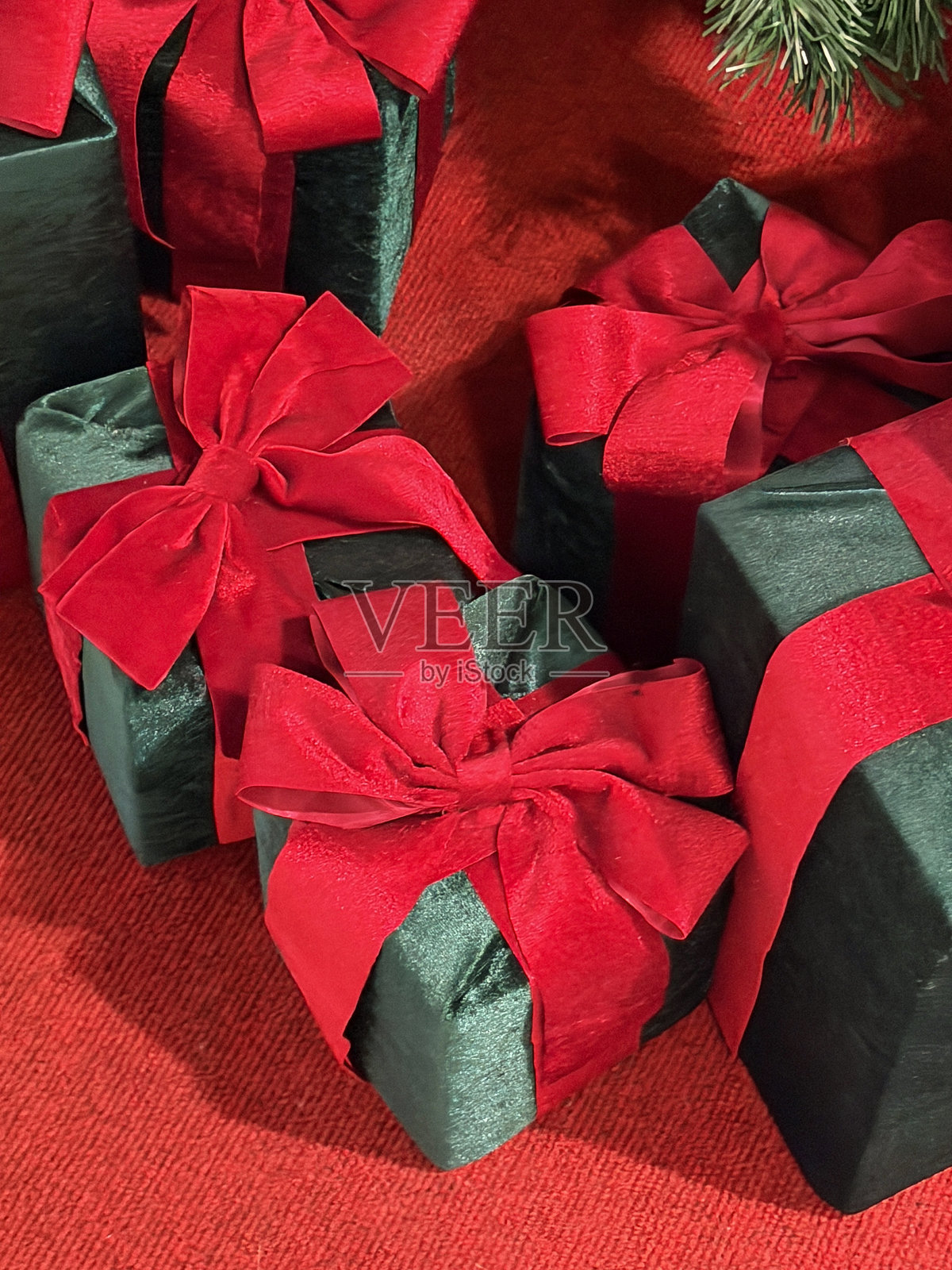 红绿色圣诞树，装饰有包装好的礼物、礼盒、蝴蝶结和丝带，呈现节日的圣诞和生日庆典氛围照片摄影图片