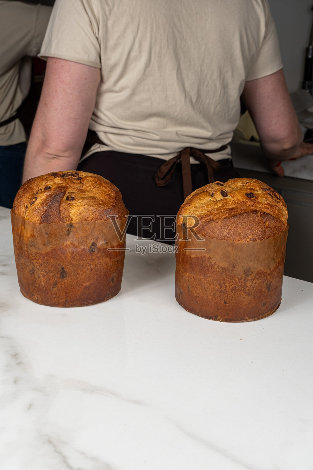大理石台面上的潘妮托尼面包，背景是糕点师_竖版照片摄影图片