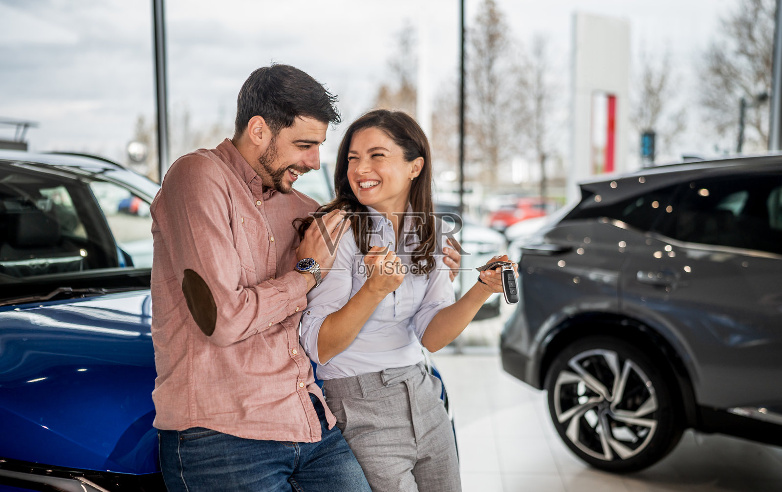 一对幸福的夫妇拿着钥匙购买新车照片摄影图片