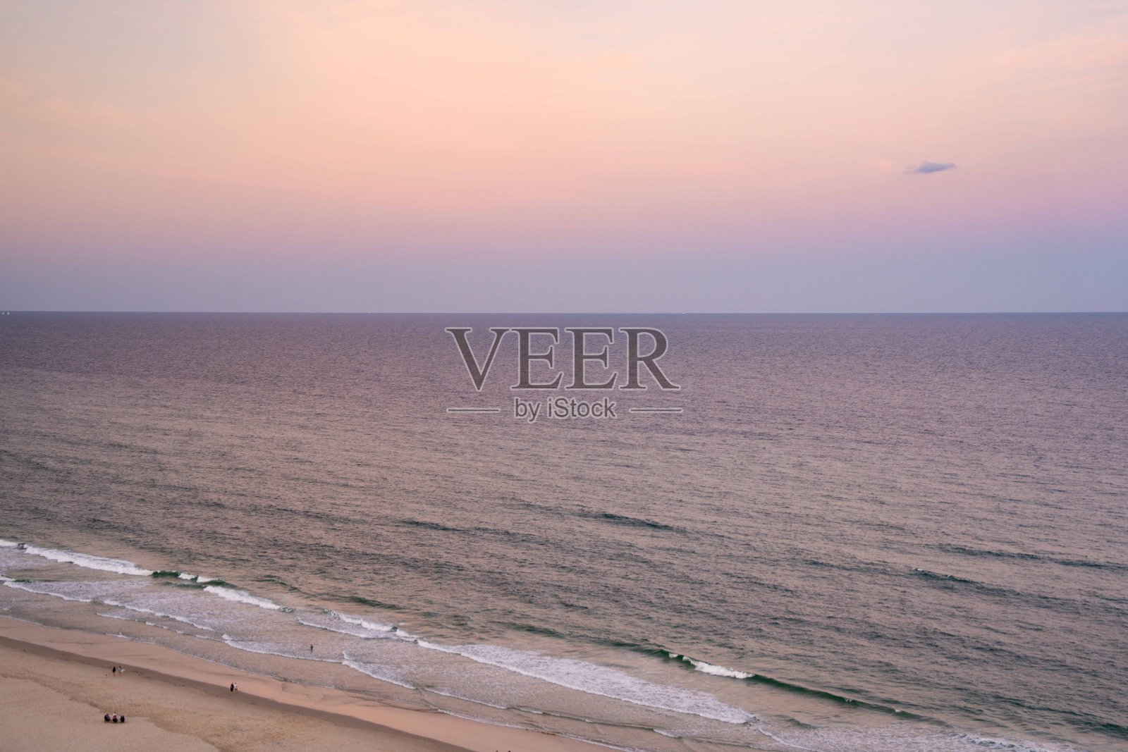 黄昏时分，宁静海滩上空的美丽日落照片摄影图片