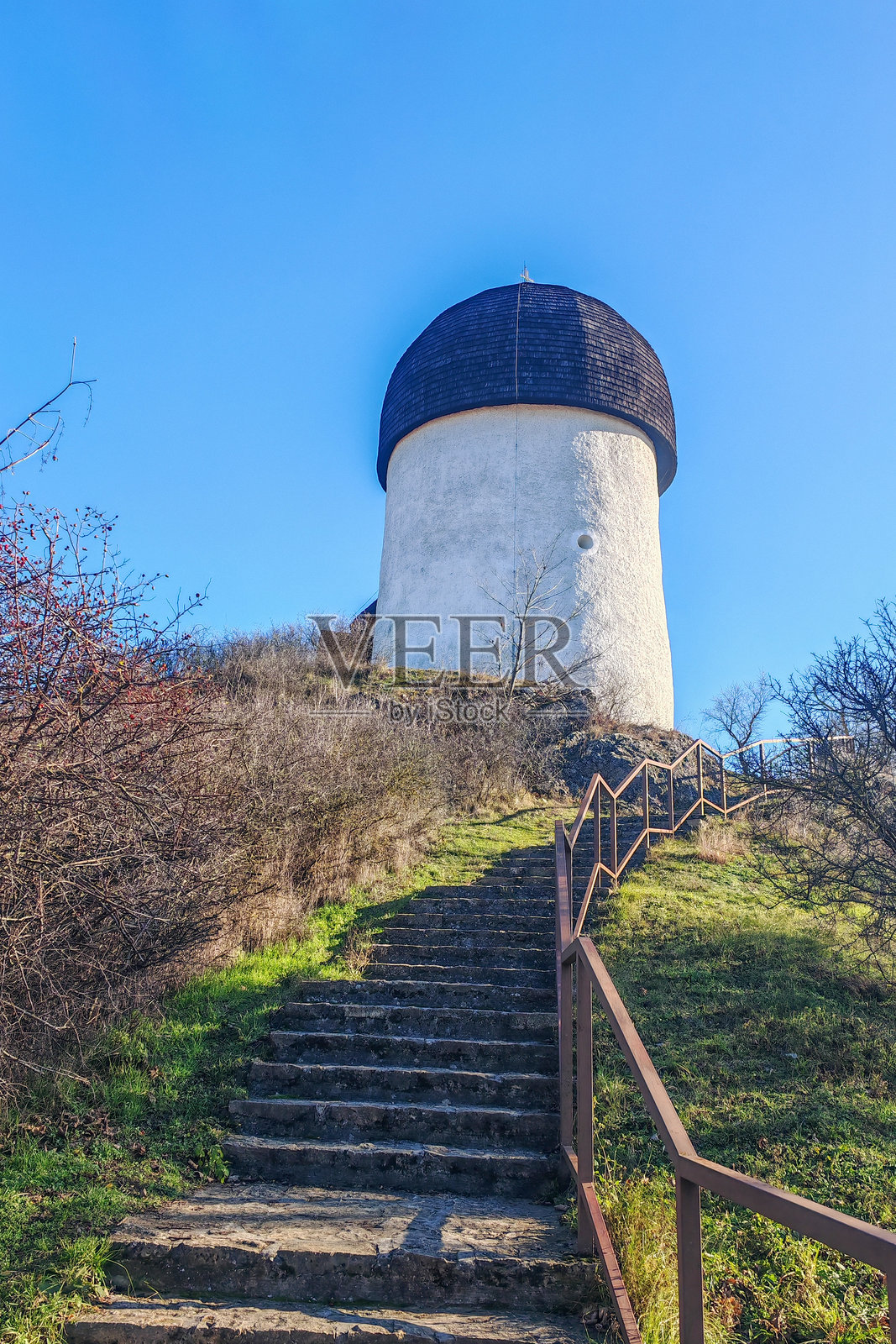 山顶上历史悠久的圆形教堂，顶部有木质圆顶照片摄影图片