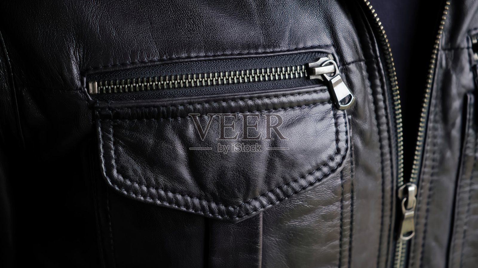 男人正在拉上皮夹克的口袋。夹克金属拉链特写。骑行服或朋克风。休闲服饰。高质量照片照片摄影图片