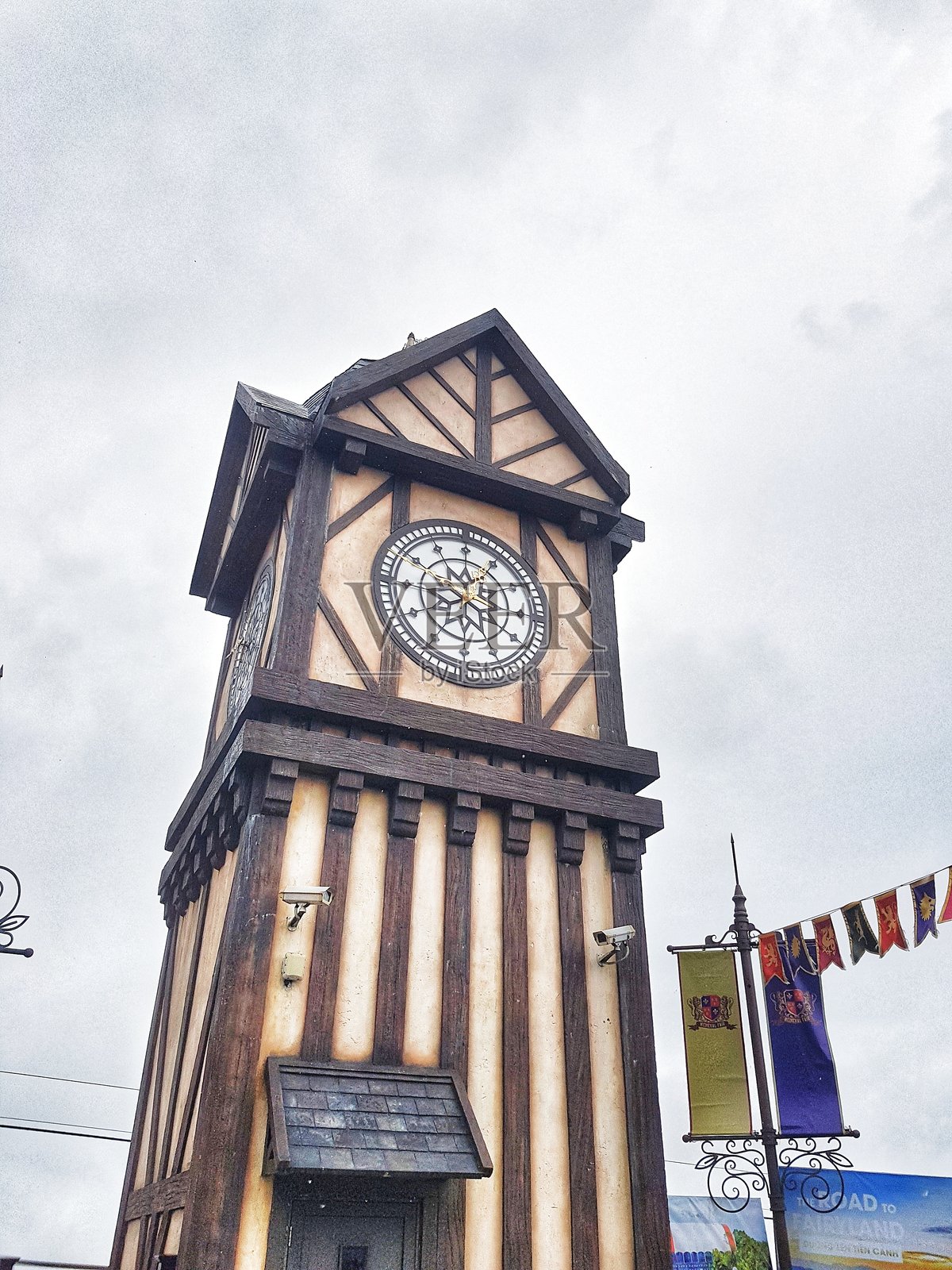 2025年5月12日，越南岘港，巴拿山。一座高大的木制钟楼，拥有精美的钟面，背景为多云的天空。照片摄影图片