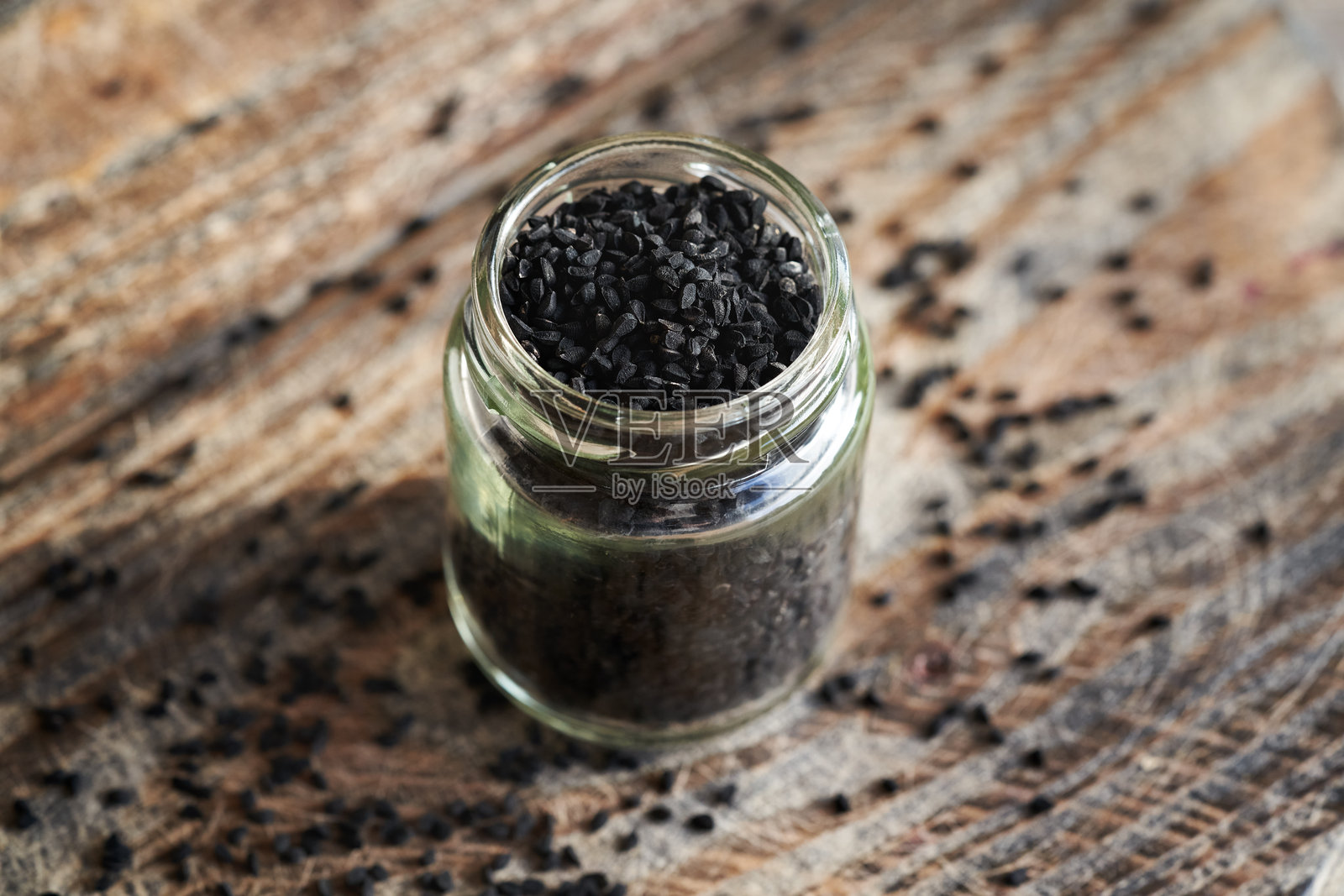 罐装的黑孜然或黑种草籽。营养补充剂。照片摄影图片