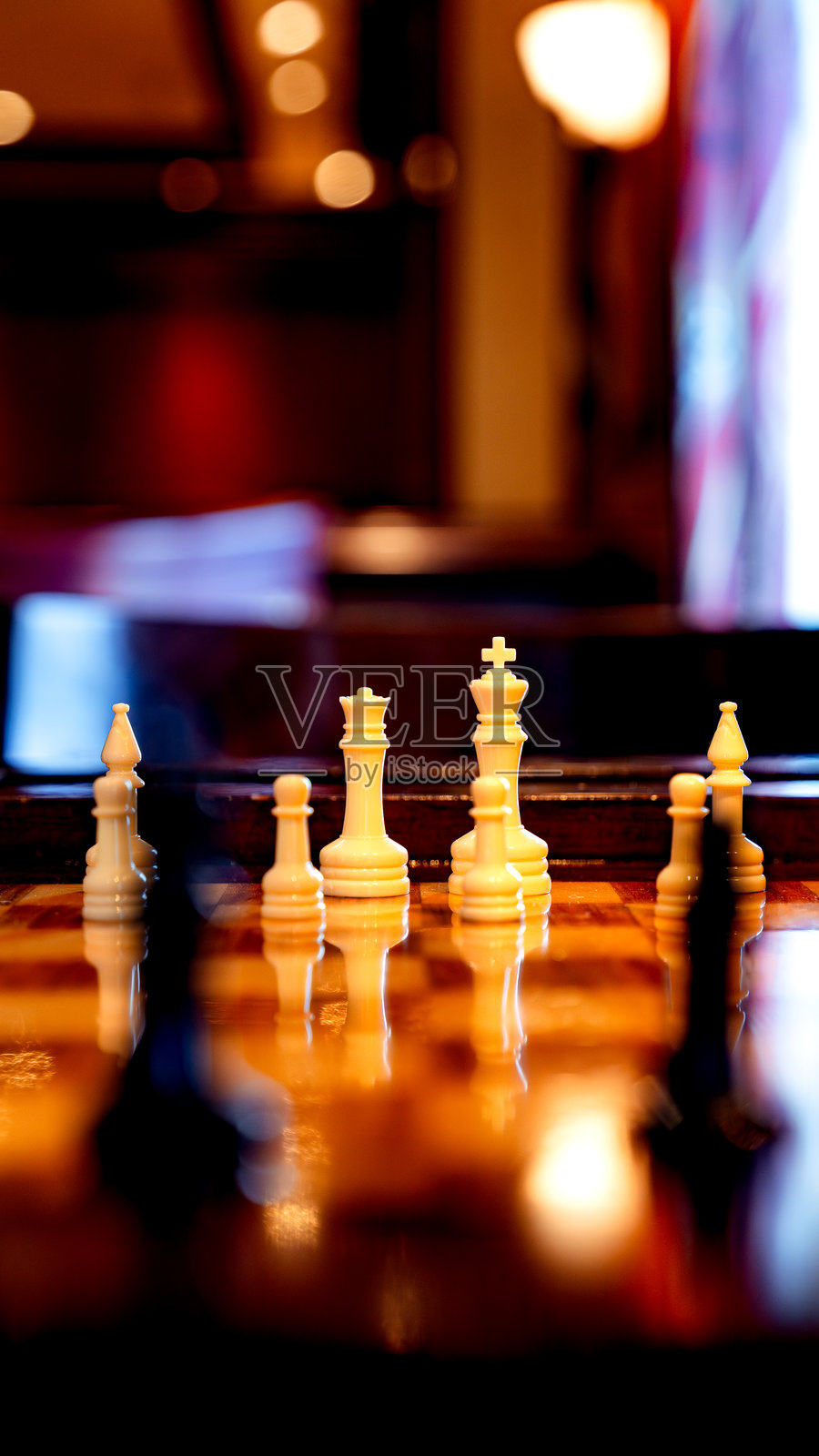 棋盘上摆放着白棋，在昏暗的房间里映出微光照片摄影图片