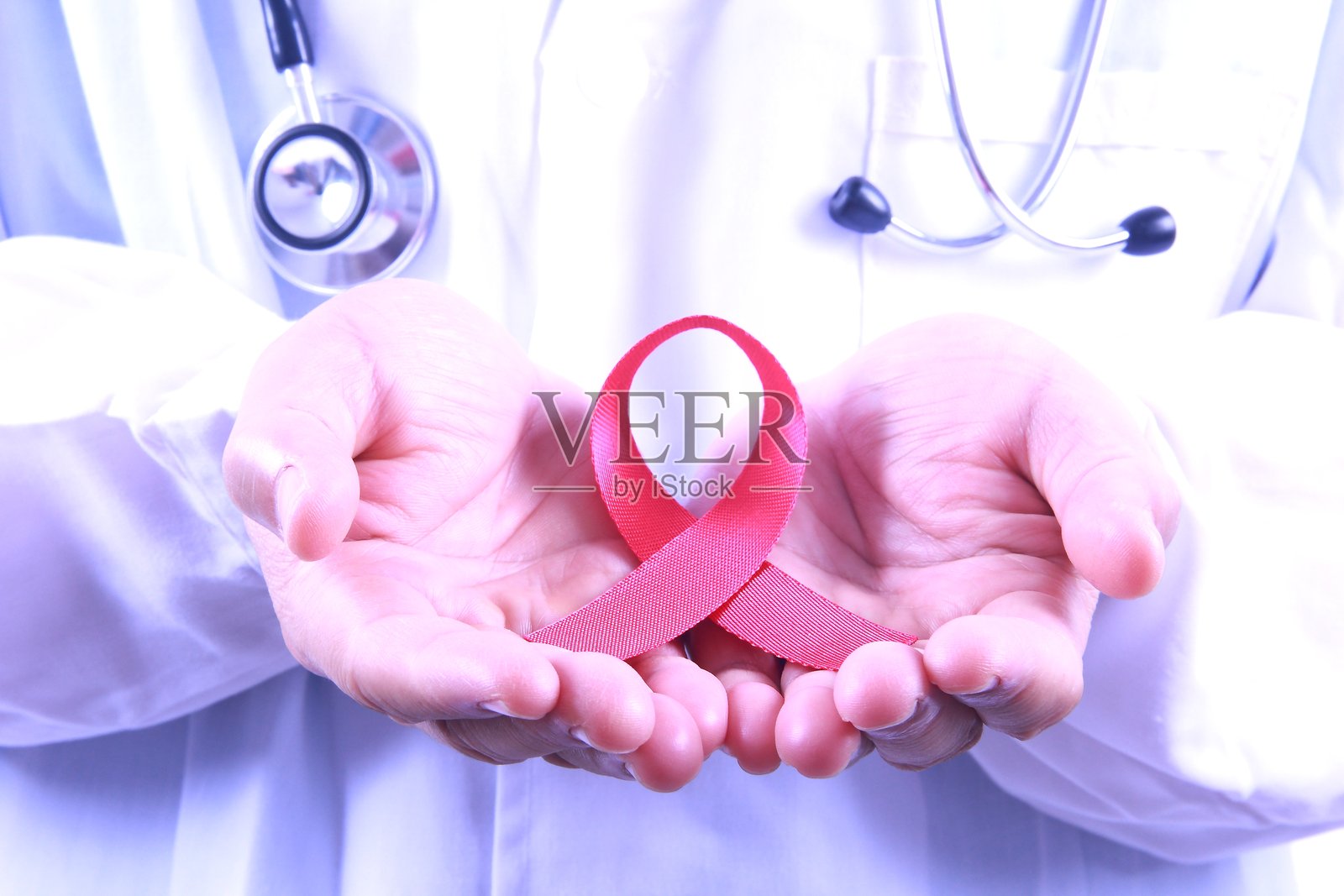 男医生手持艾滋病宣传红色丝带照片摄影图片