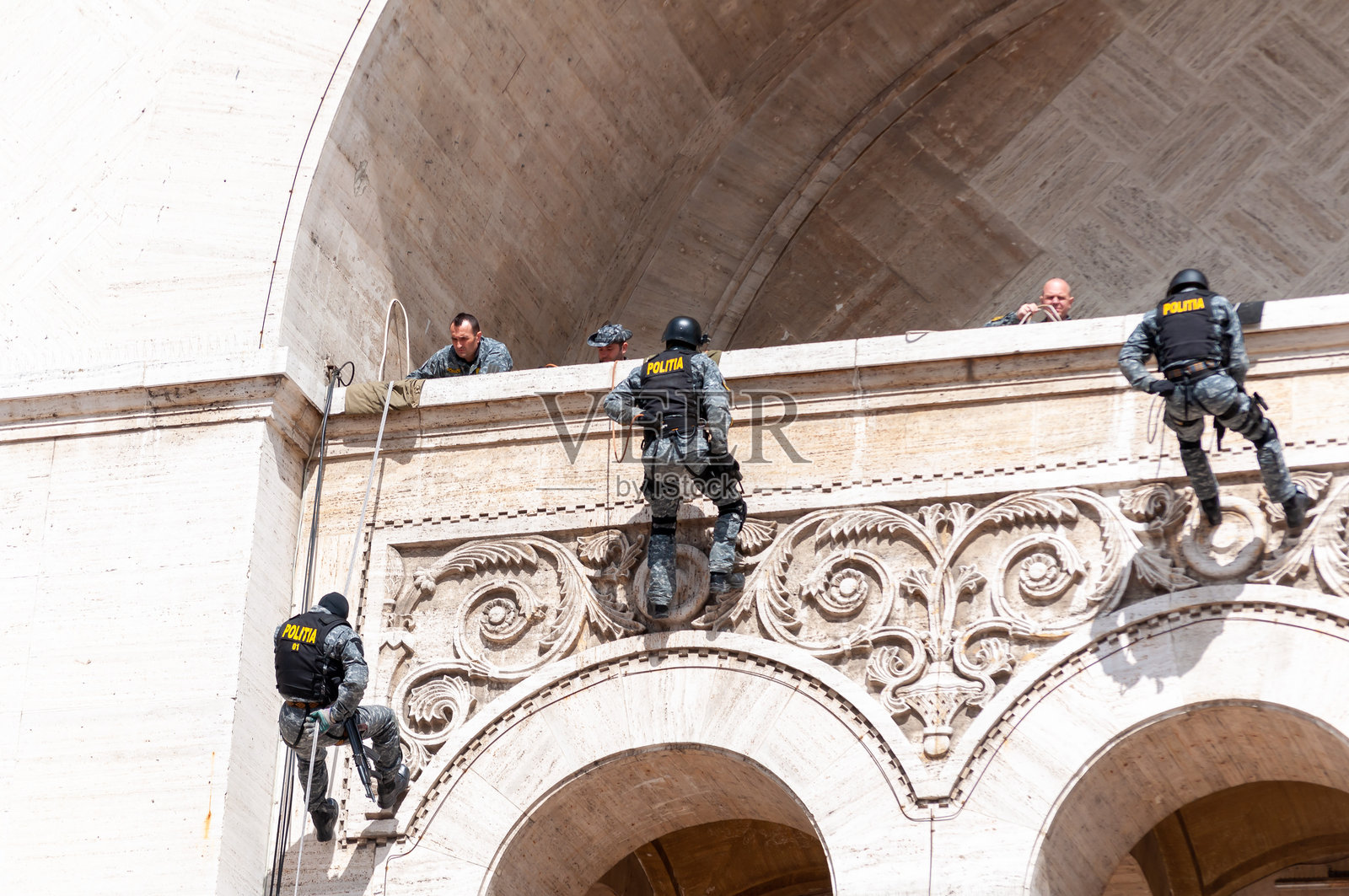 人们在绳索上向下攀爬照片摄影图片