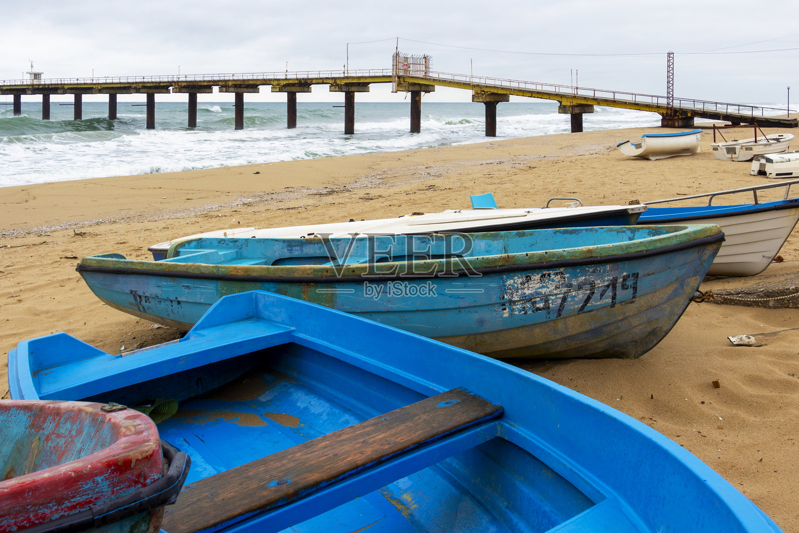 保加利亚北部黑海沿岸，科学码头前停靠着老旧的、饱经风霜的渔船照片摄影图片