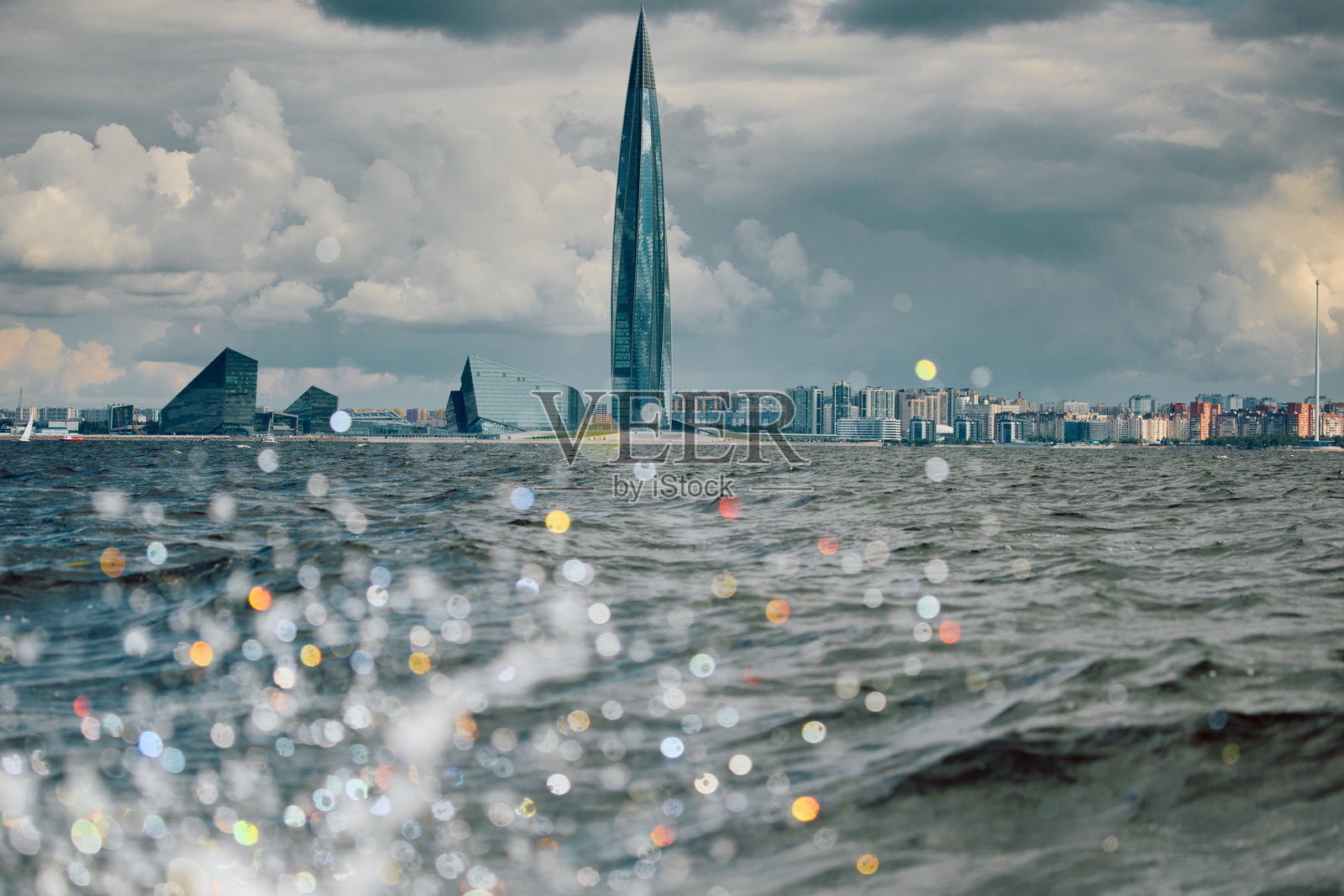 俄罗斯，圣彼得堡，2025年8月1日：欧洲最高摩天大楼拉赫塔中心位于芬兰湾岸边，伴有水花飞溅的全景视图照片摄影图片