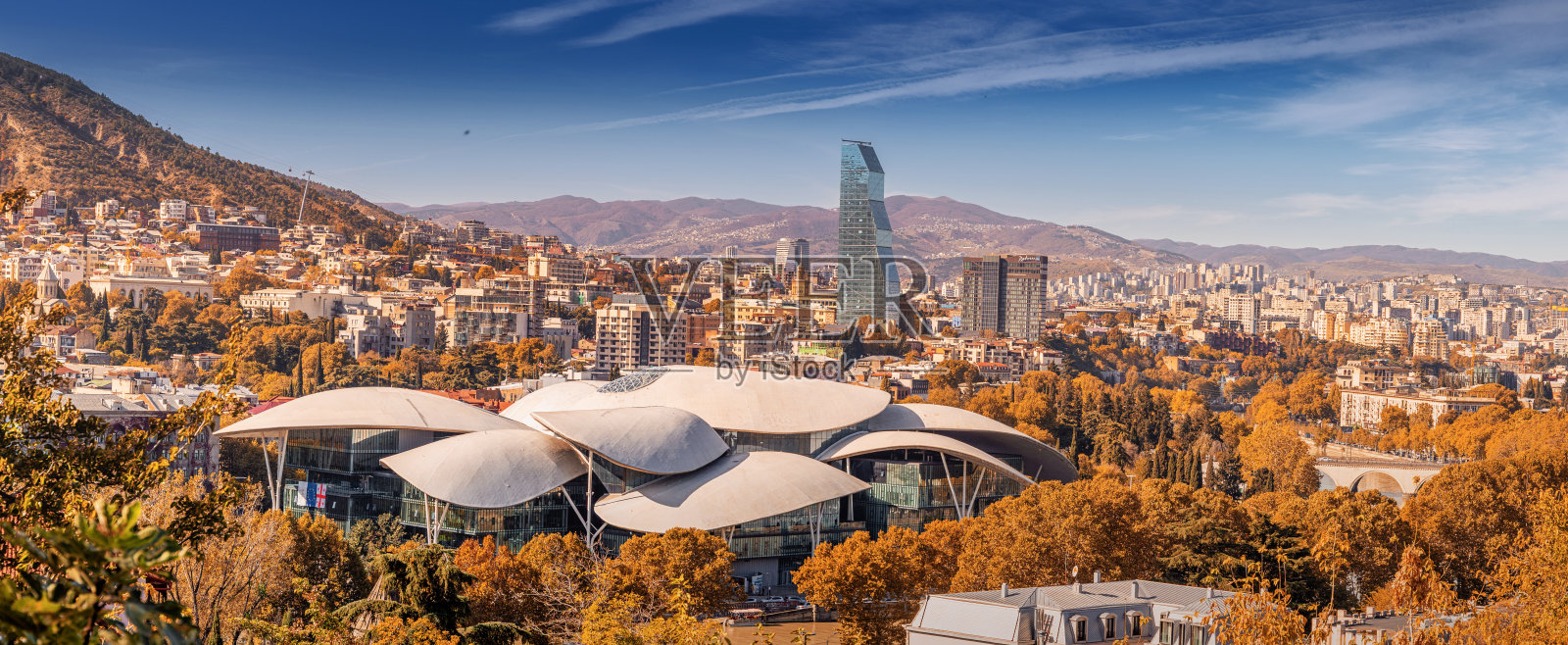 秋季的城市景观，包含公共服务大厅和山脉，展示了现代建筑照片摄影图片