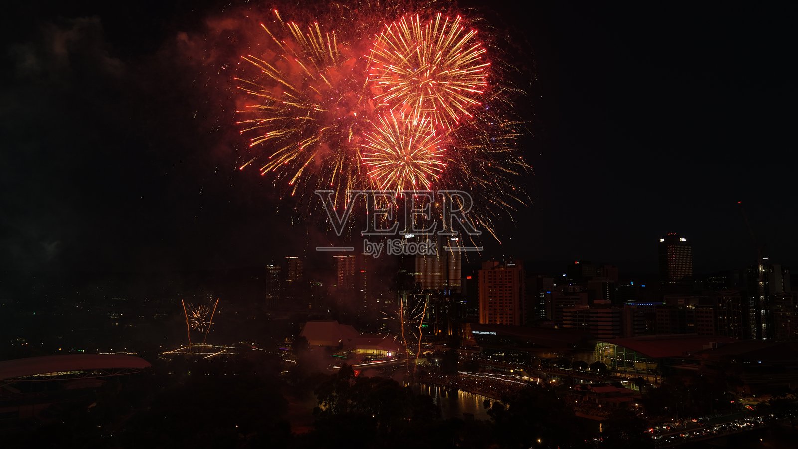 澳大利亚南澳州阿德莱德市——新年除夕庆祝活动的烟花空中无人机视角，展现夜间天际线、河畔区、节日灯光、城市景观和壮观的烟花表演照片摄影图片