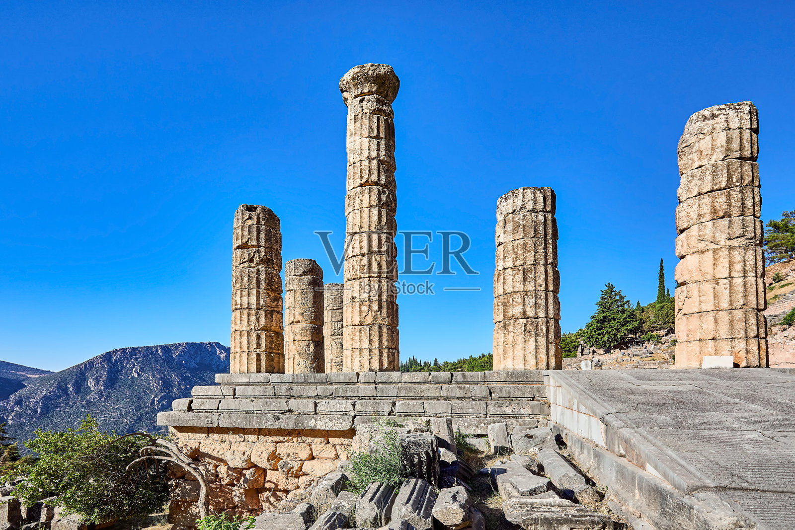 德尔斐阿波罗神庙的柱廊遗址，这座古老的神庙仅剩几根石柱，建于公元前4世纪，坐落在一座更古老神庙的遗址之上。地点：德尔斐，中希腊，希腊，欧洲。照片摄影图片