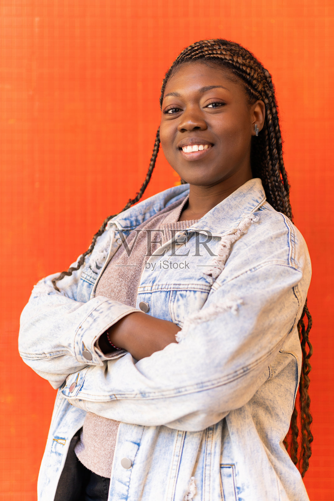 一位年轻的黑人女性微笑着，双手交叉在胸前照片摄影图片