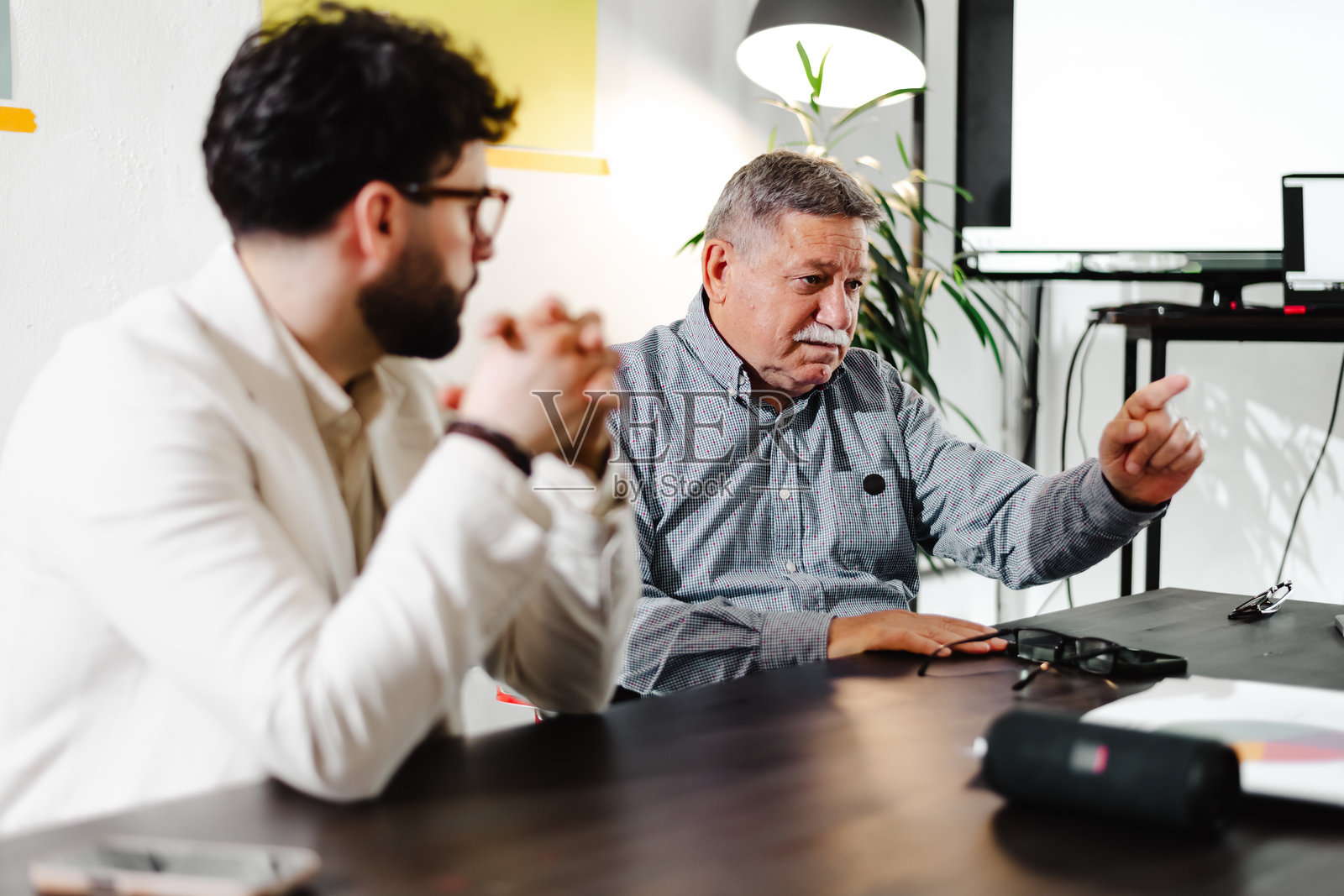 两位商务人士在现代办公室会议中进行讨论，分享想法和见解照片摄影图片