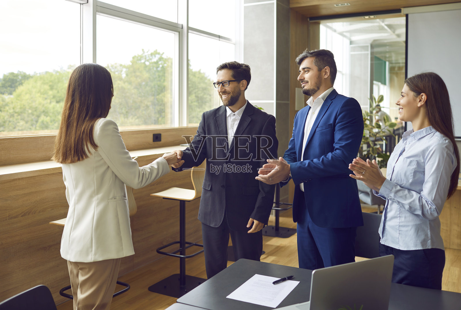 一群商务人士在办公室开会，达成协议并握手照片摄影图片