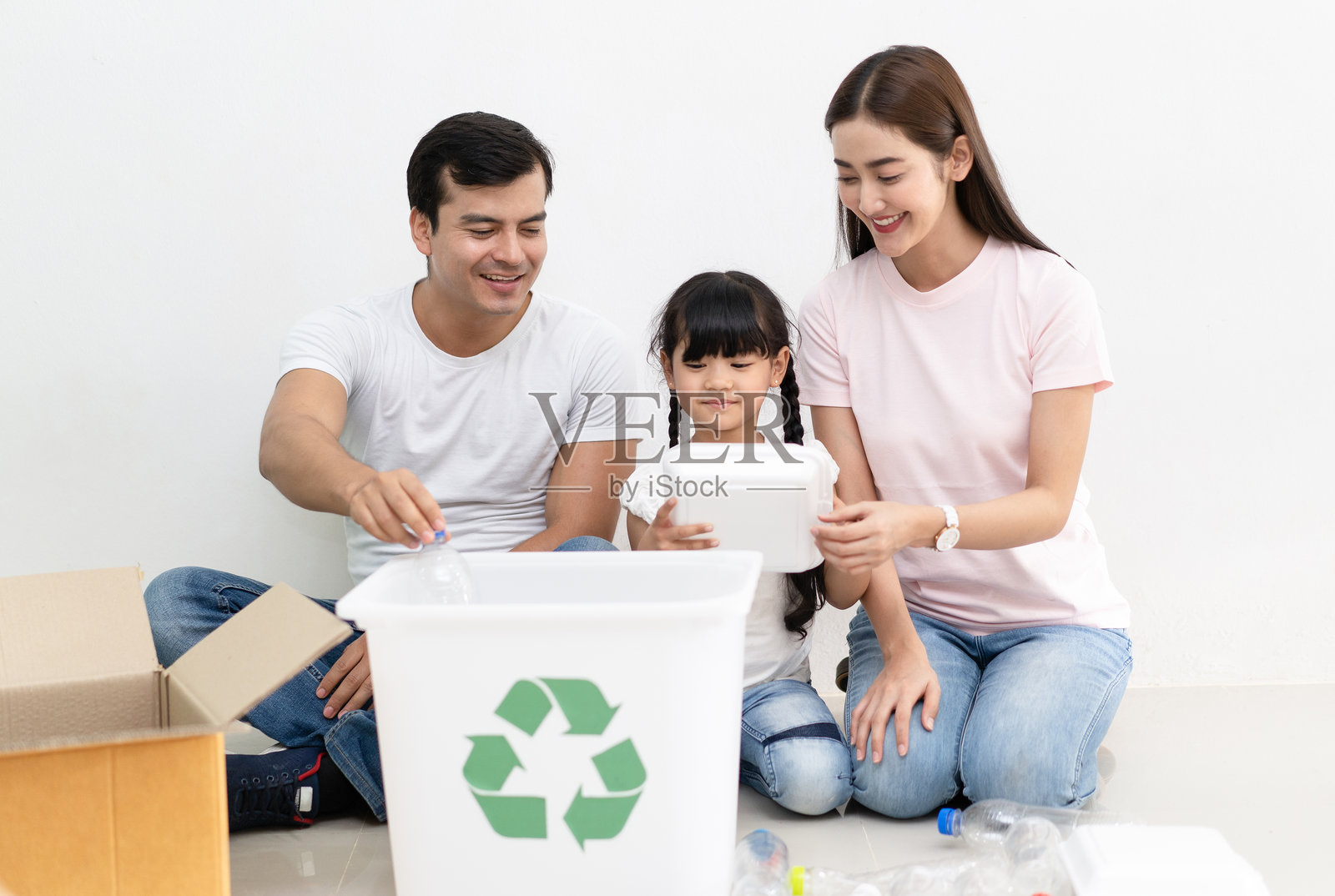 快乐的多民族家庭兄弟姐妹在家中进行垃圾分类，玩得很开心。生活方式 - 生态教育和环保意识概念。照片摄影图片