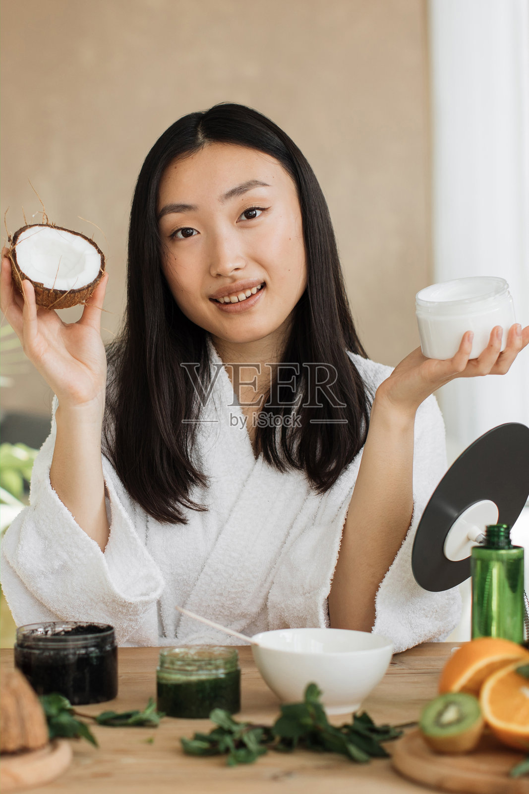 女子手持椰子和奶油照片摄影图片