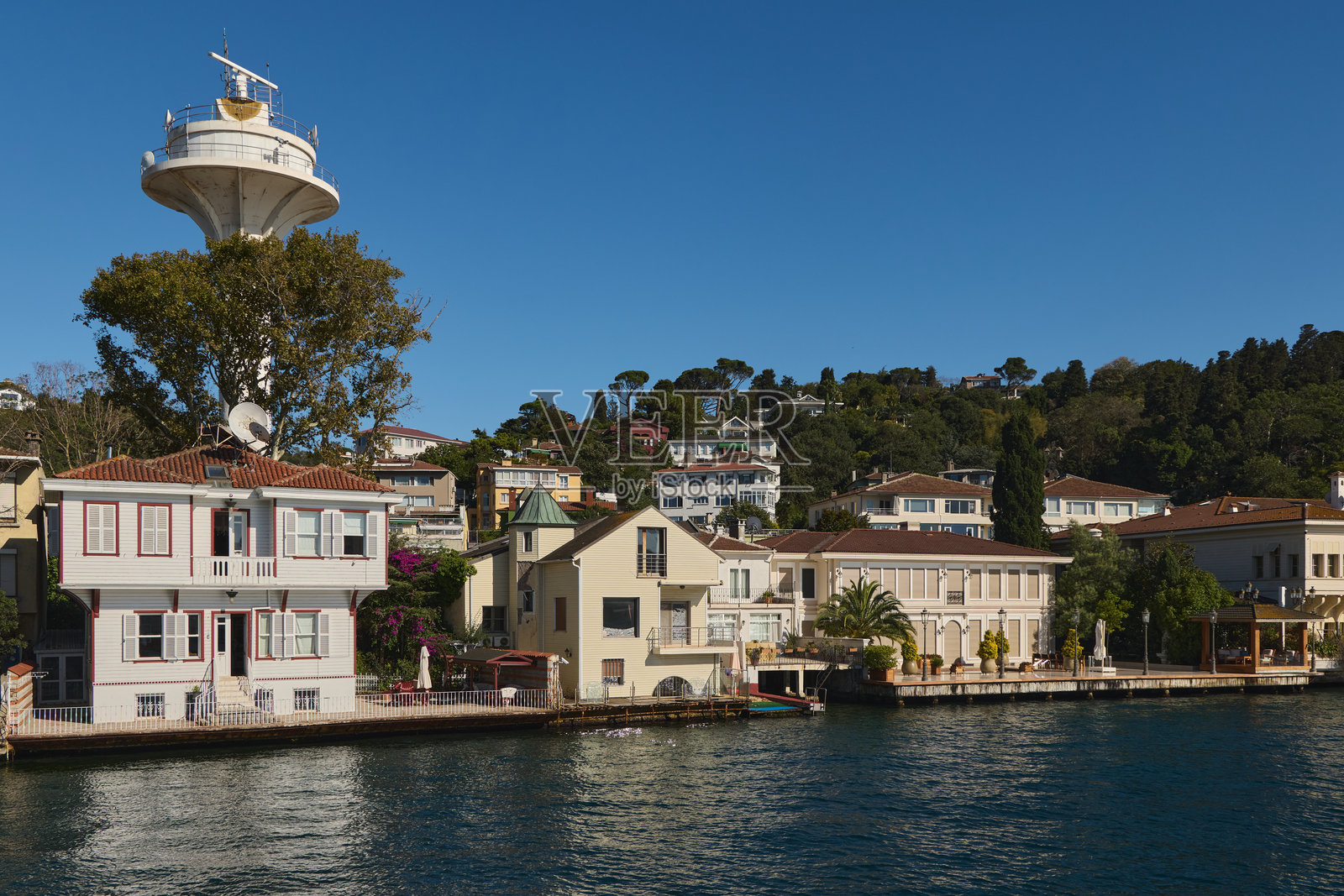 伊斯坦布尔的白色传统亚力(Yali)和VTS雷达塔照片摄影图片