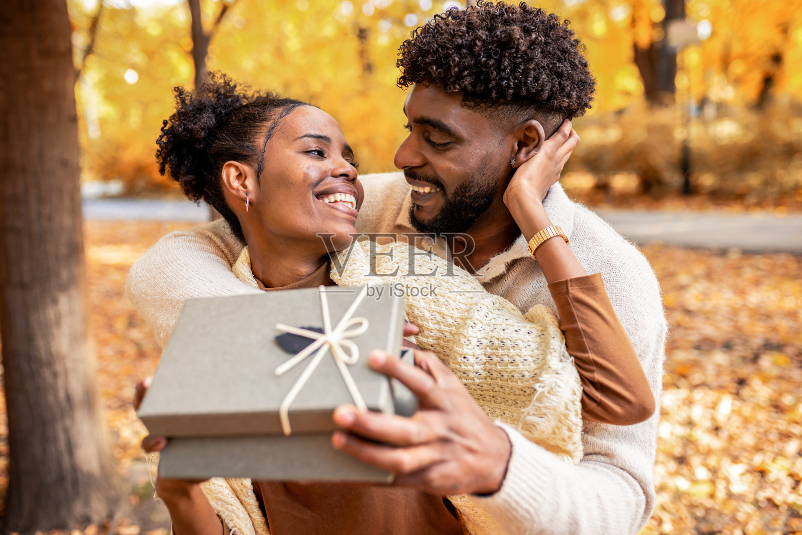 情侣在秋日公园分享甜蜜惊喜照片摄影图片