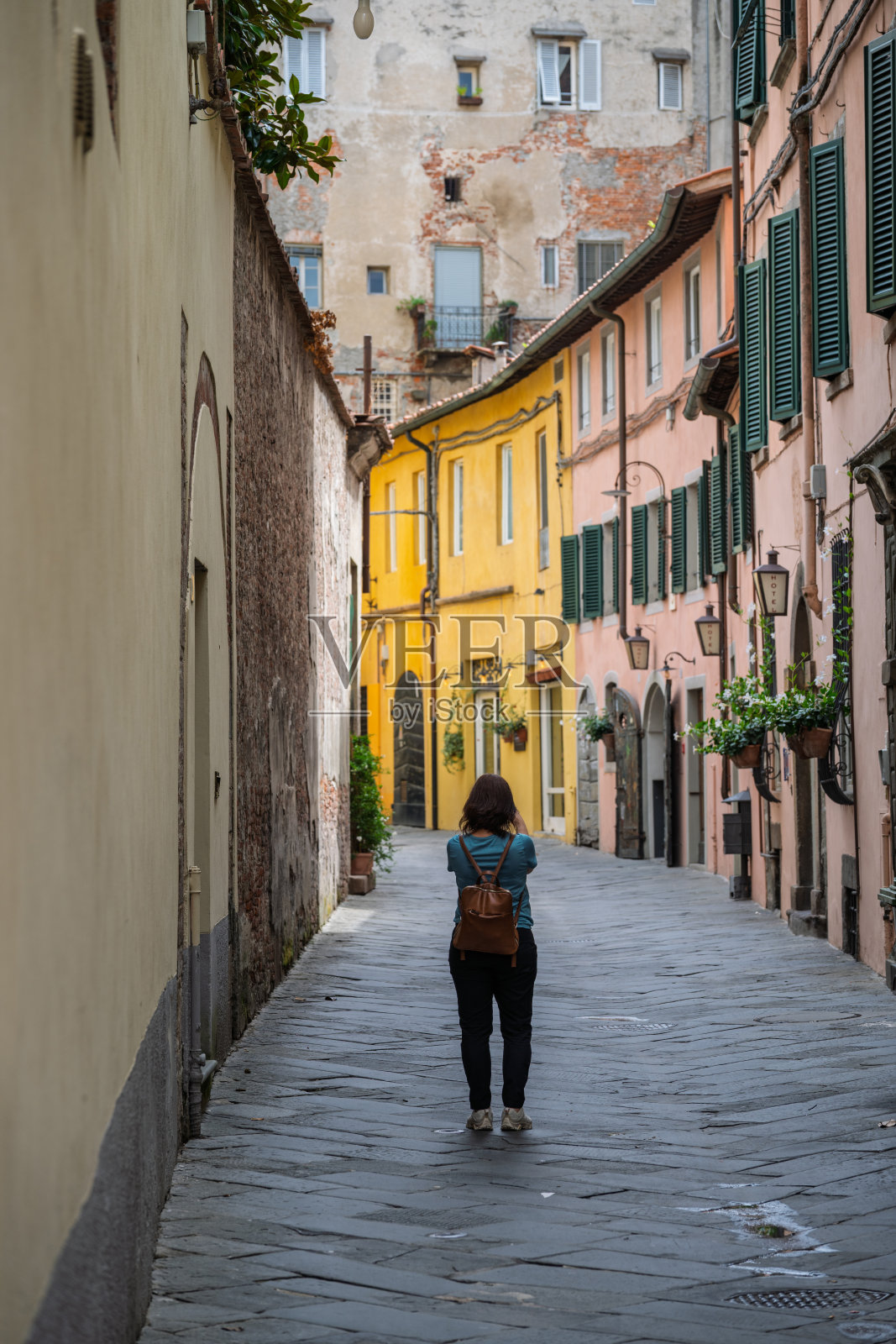 女子探索卢卡弯曲的中世纪街道照片摄影图片