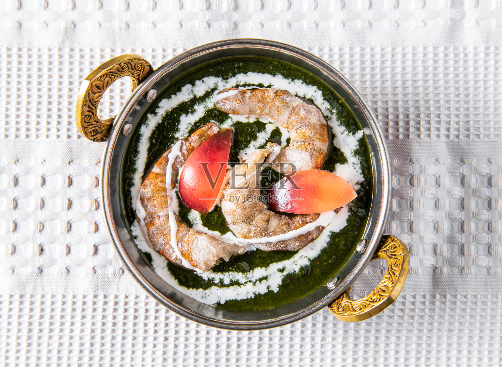 美味的菠菜虾咖喱，配鲜绿酱汁和新鲜番茄，俯视角度照片摄影图片