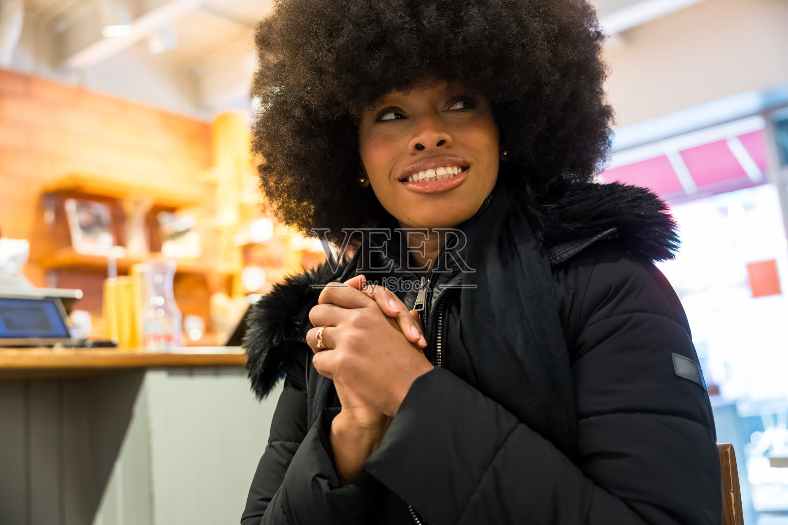 年轻的黑人女性坐在纽约市的咖啡馆里照片摄影图片
