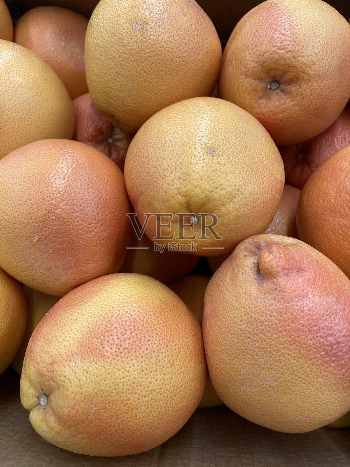 一盒摞起来的葡萄柚，展示了适合健康饮食背景的新鲜柑橘类水果照片摄影图片