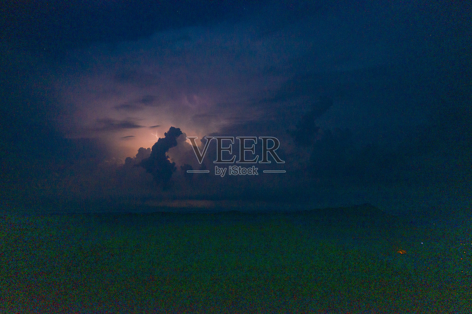 远处的闪电照亮了夜晚的雷暴云照片摄影图片