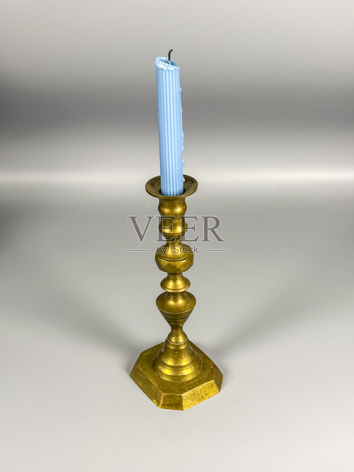 带蓝色蜡烛的烛台，立在平坦的表面上照片摄影图片