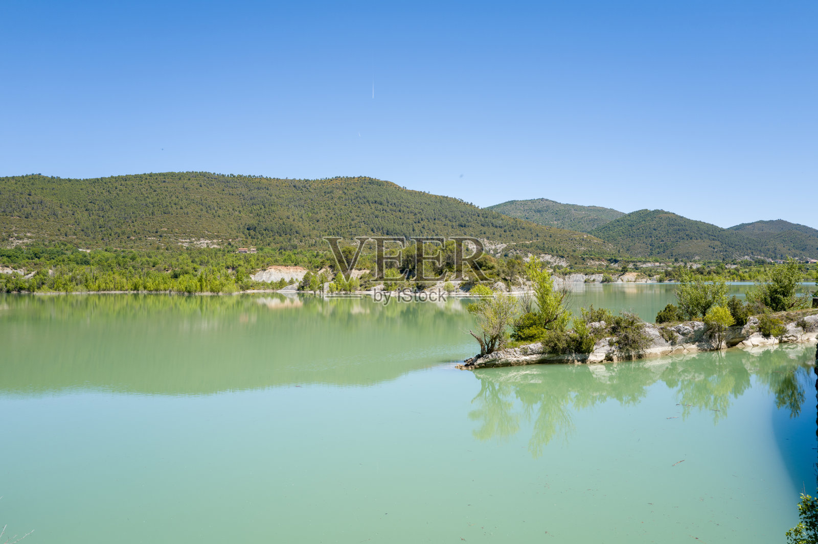 宁静的绿松石色湖泊与森林覆盖的山丘照片摄影图片