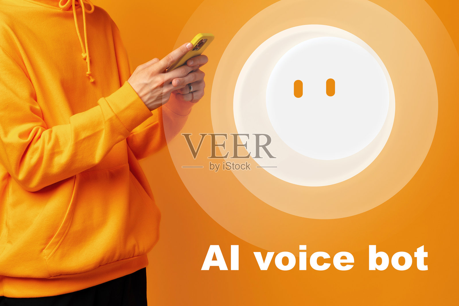 身穿橙色连帽衫的人正在使用手机，屏幕上显示着一个白色的语音助手照片摄影图片