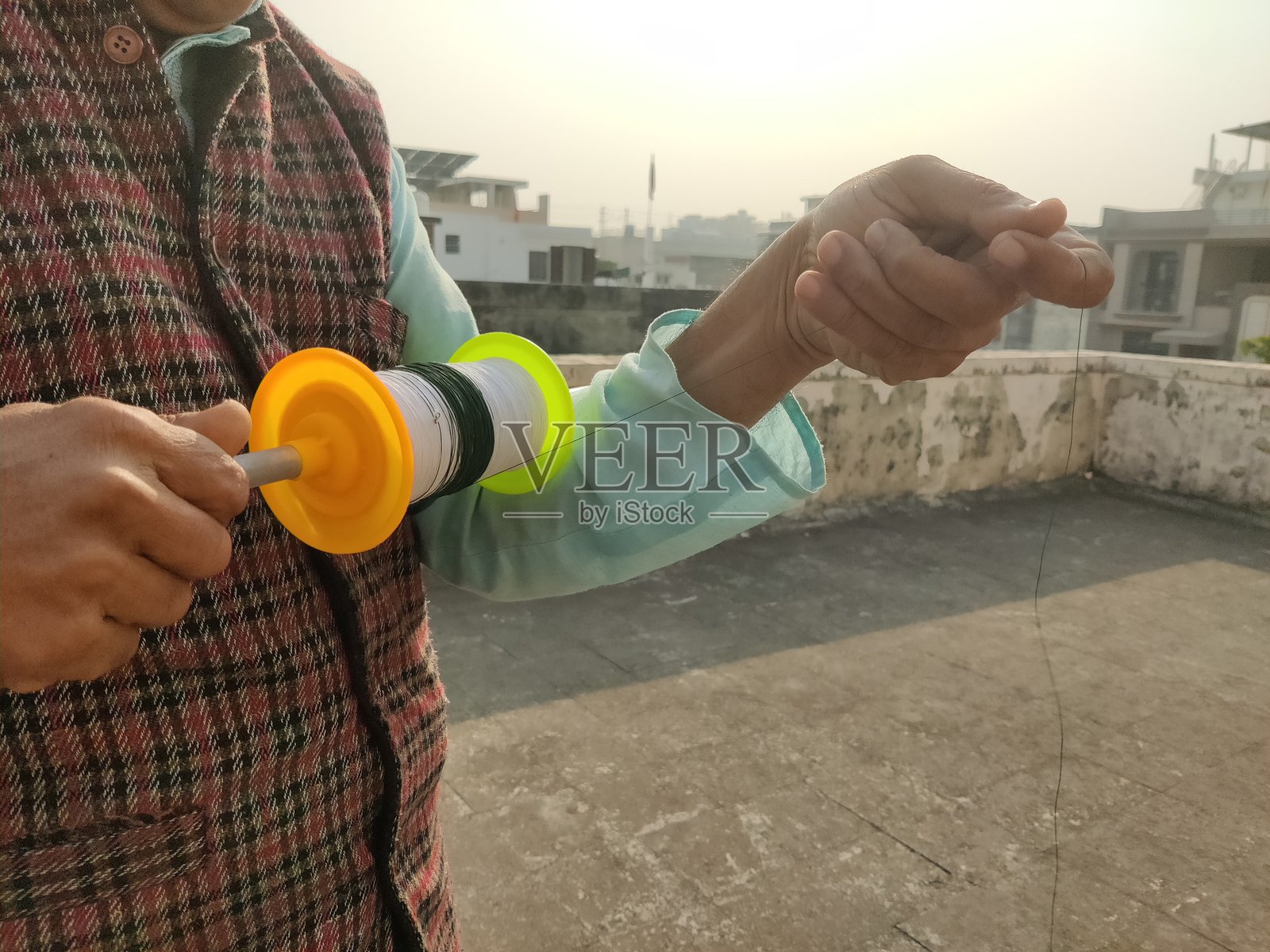 一个人手持风筝线轴照片摄影图片