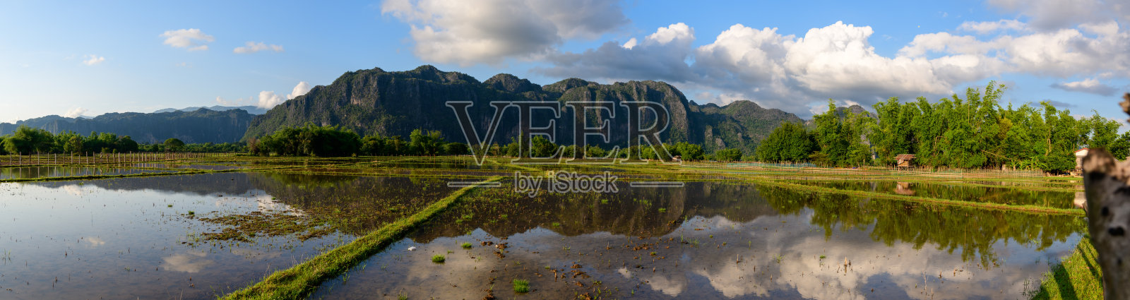 日落时分，稻田映照着石灰岩山脉照片摄影图片