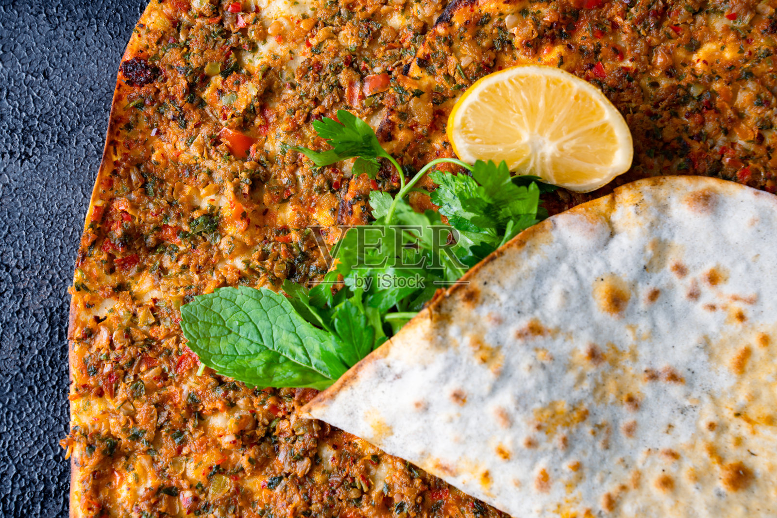 黑色石材背景上的大号土耳其披萨照片摄影图片